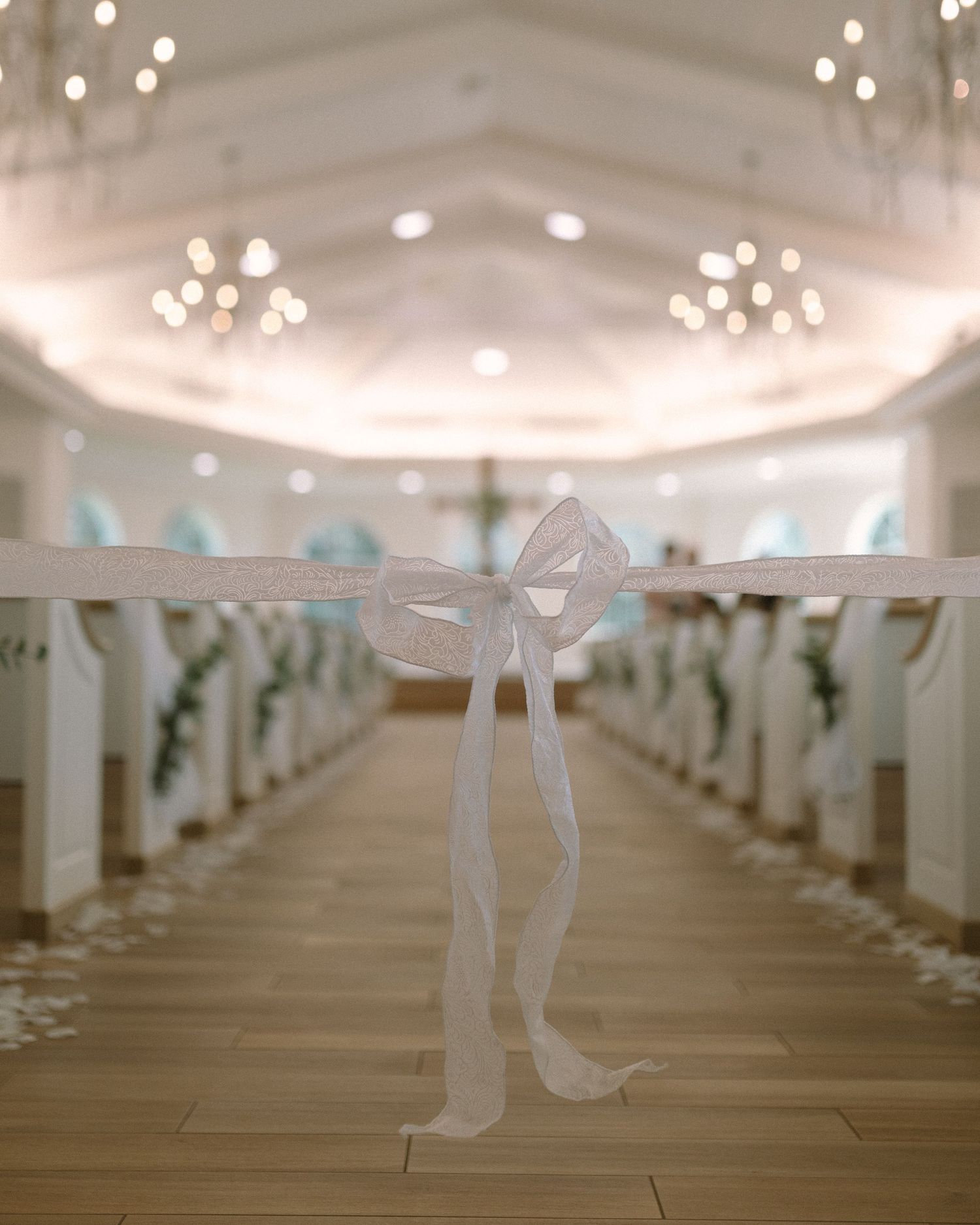 Bride in veil standing by soft drapery, a quiet and emotional portrait capturing anticipation before the ceremony.