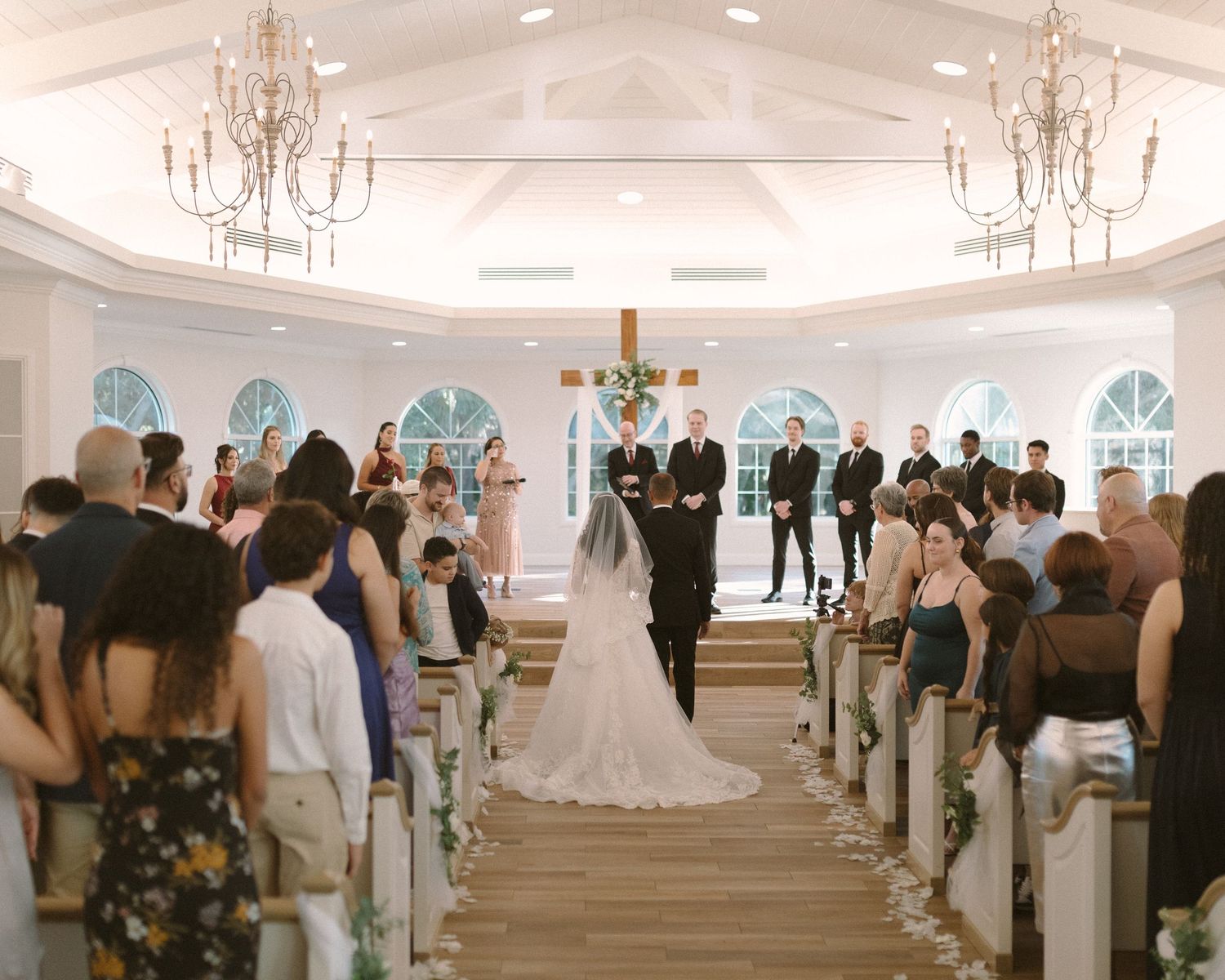 Newlyweds share their first kiss during the ceremony exit, surrounded by cheering guests.