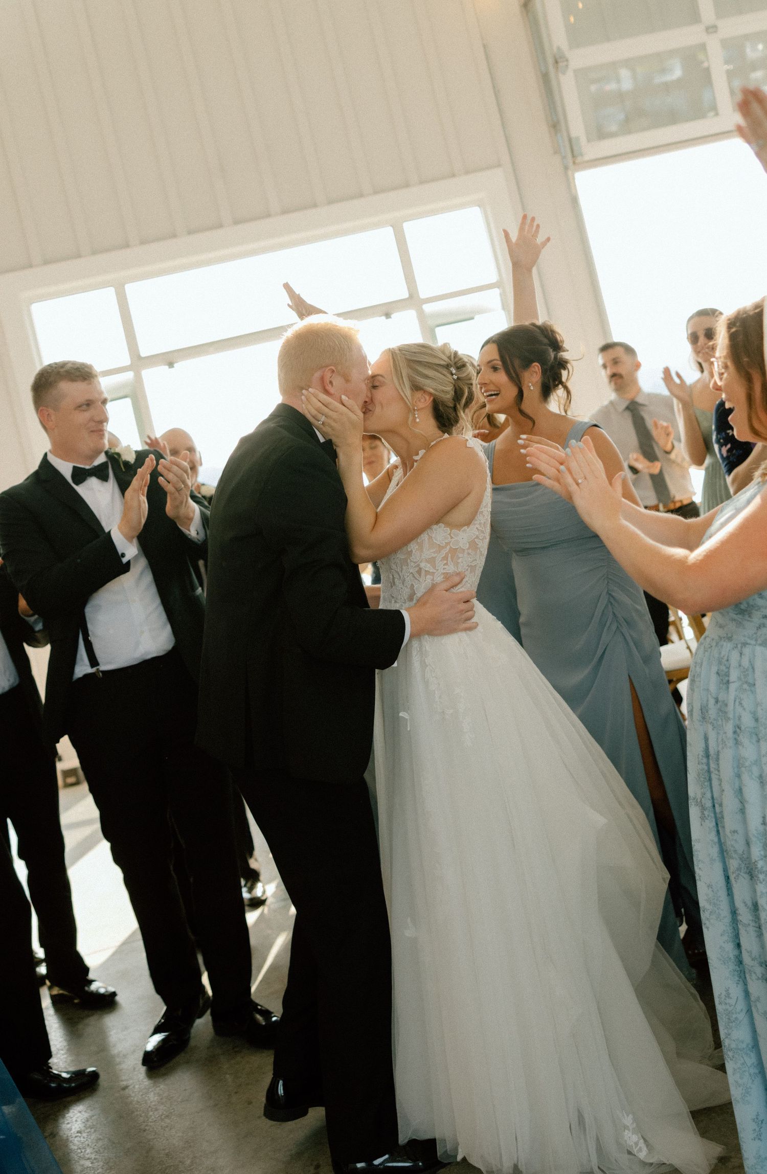 Wedding guests dance together in a line during a reception celebration.