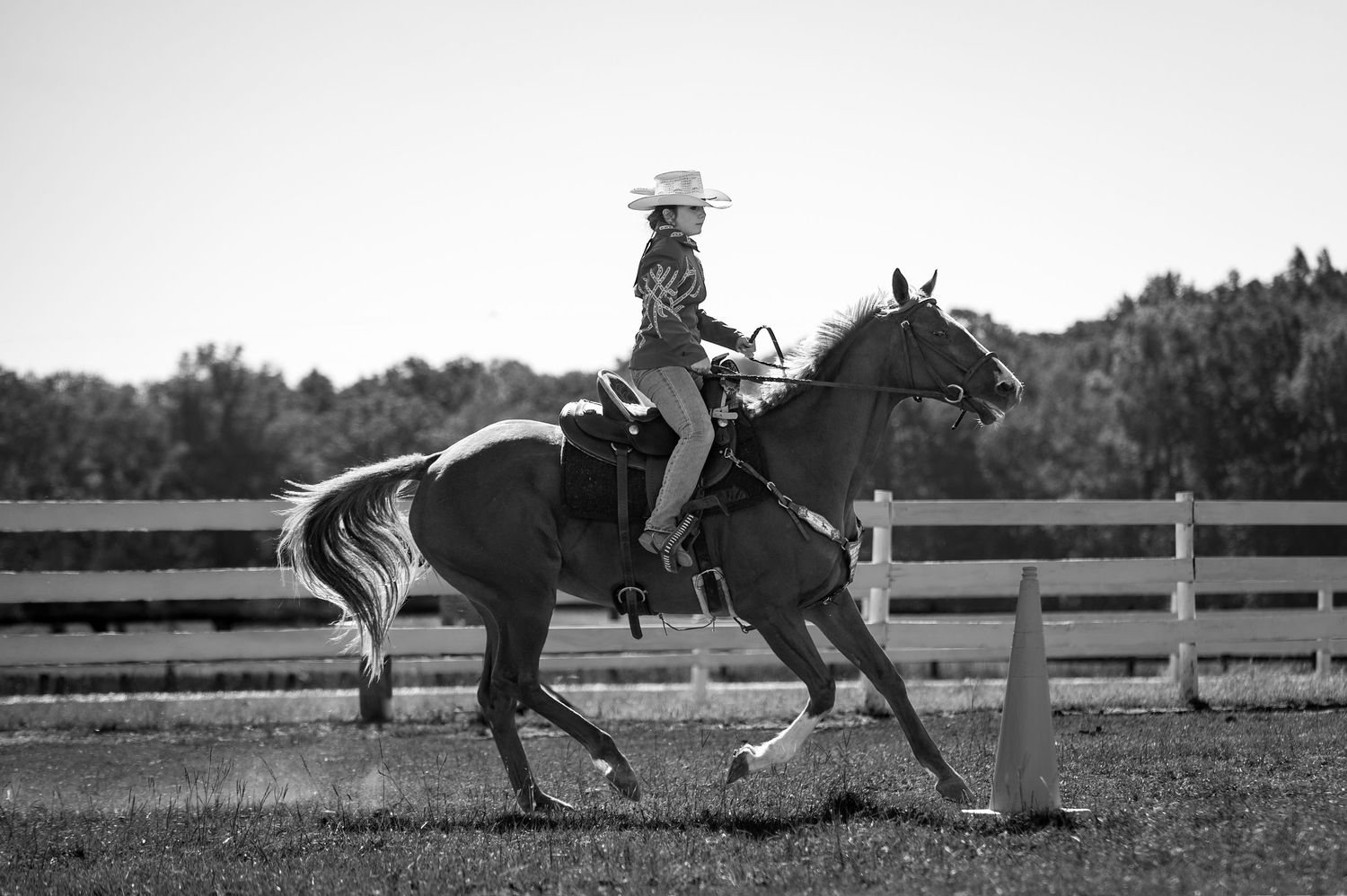 Black-and-white photo of a Western rider guiding a horse around a cone at the Haunted Hooves horse show in Thomson, GA.
