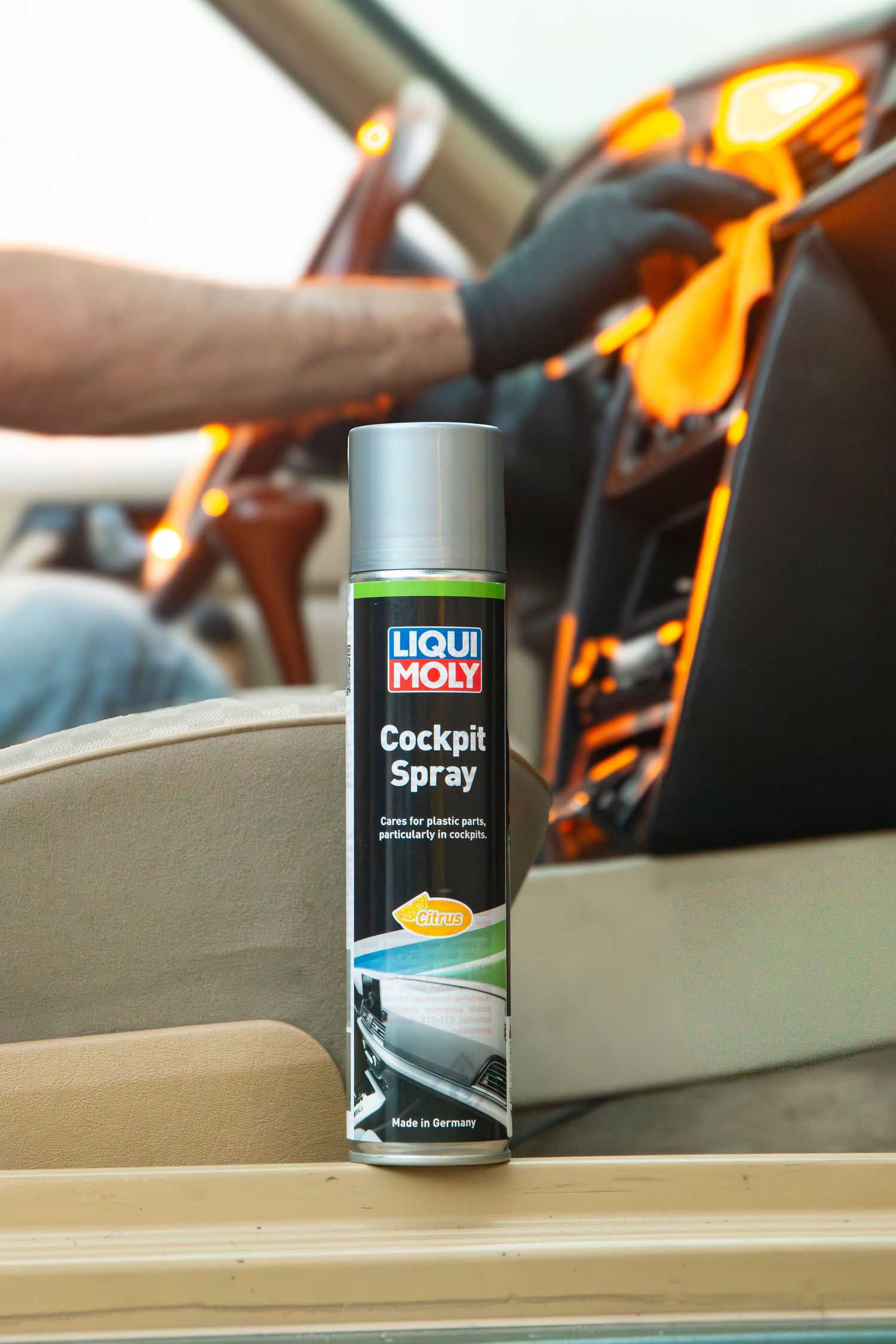 Liqui Moly Cockpit Spray can for car interior plastic care, displayed inside a vehicle dashboard.