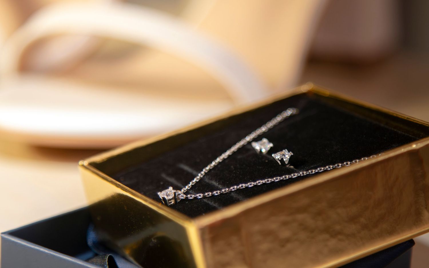 Elegant diamond necklace displayed in a black jewelry box with golden trim.