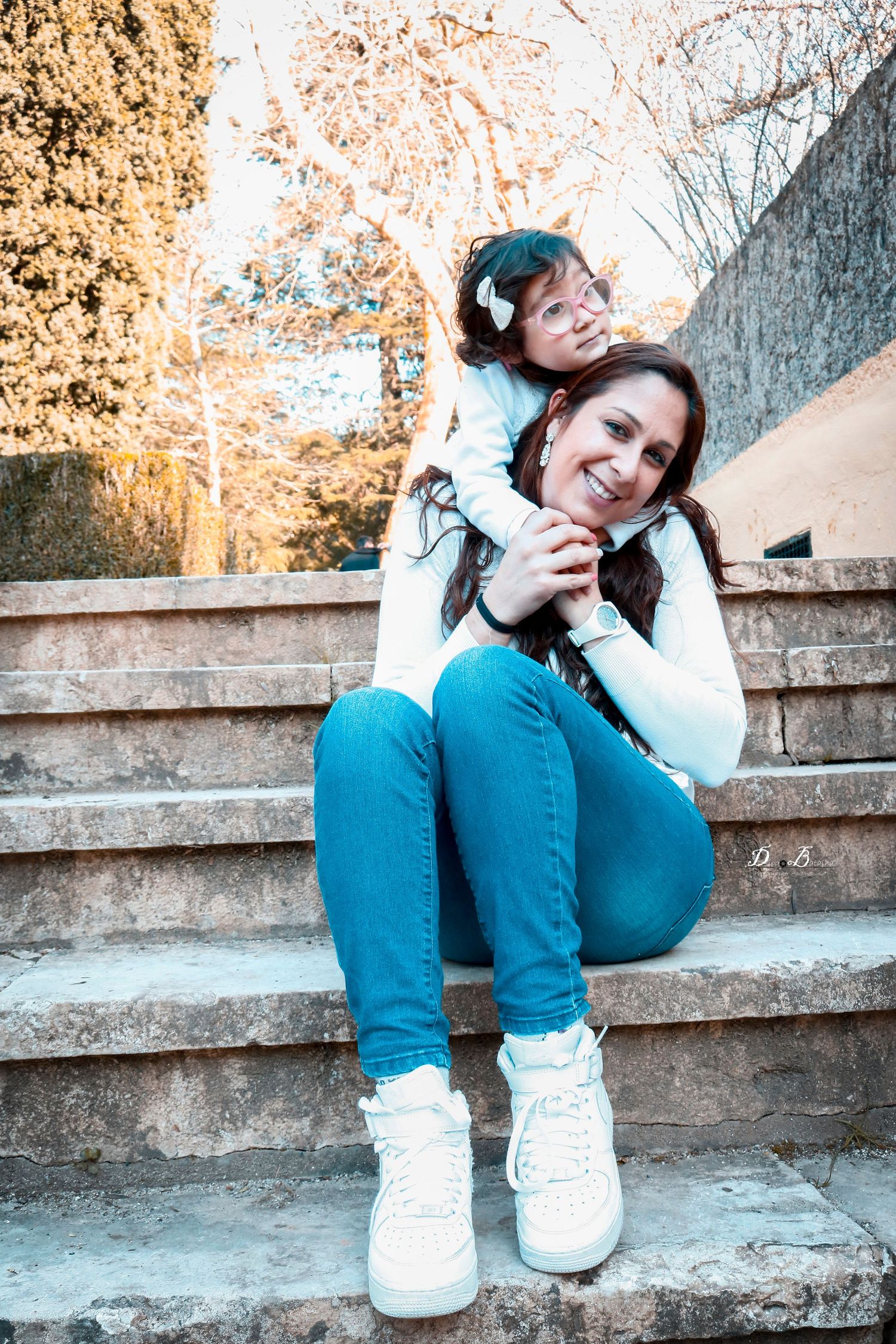 Two people sharing a joyful moment together on concrete steps outdoors.