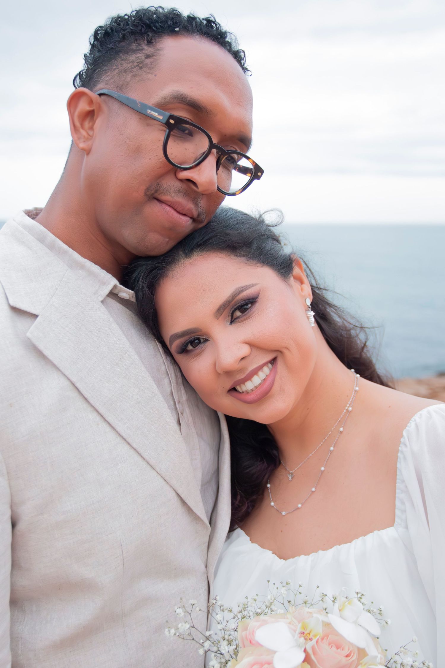 Romantic wedding photo sequence showing a happy couple embracing outdoors with an ocean view in the background.