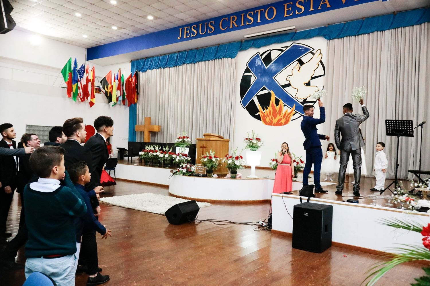A church wedding ceremony setup with international flags and a large decorative backdrop.