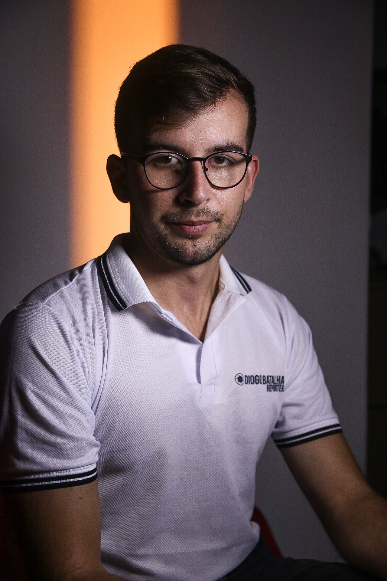 Studio portrait with dramatic lighting against dark background.