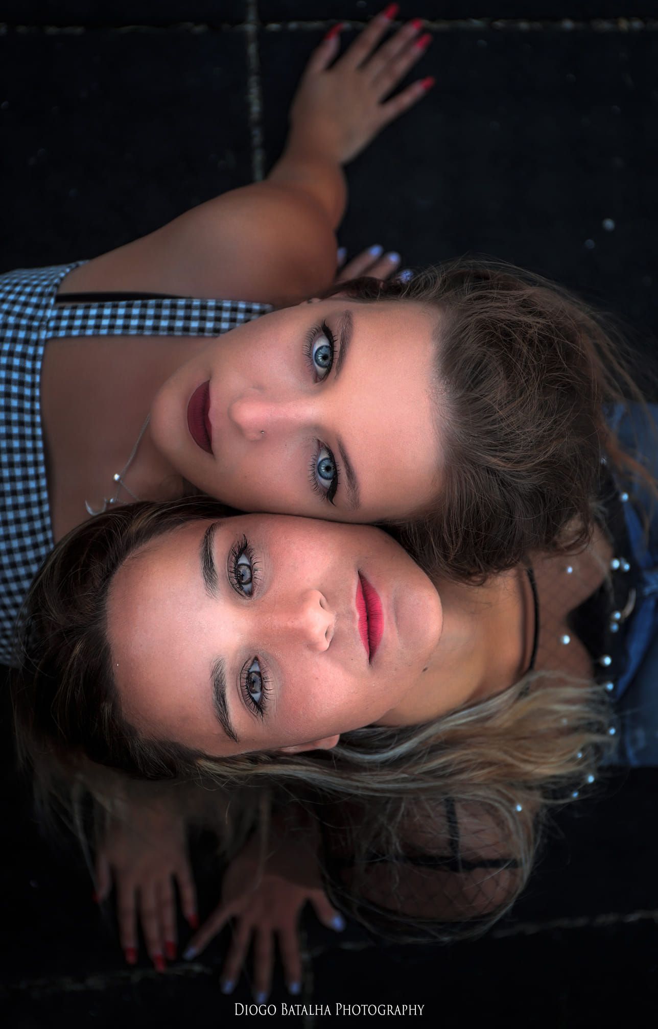 Creative mirror reflection portrait of two friends in gingham dress.
