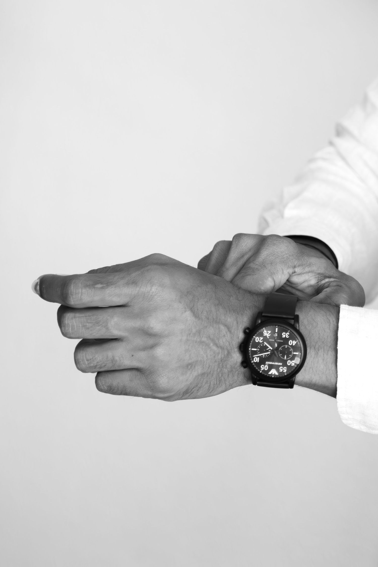 A sequence of hands holding and passing a watch between each other on a white background.