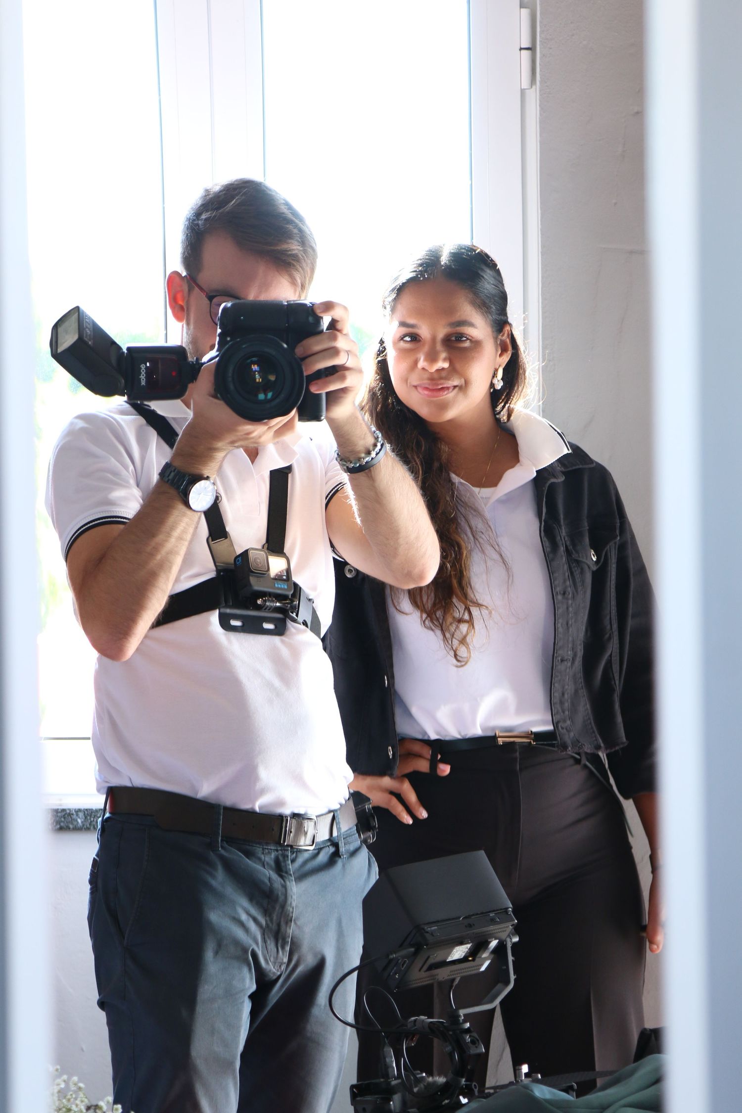 Photography team posing with professional camera equipment in studio.