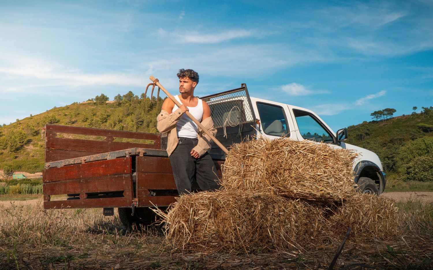 A sequence of photos showing a truck tipping over while unloading hay bales in a grassy field on a sunny day.