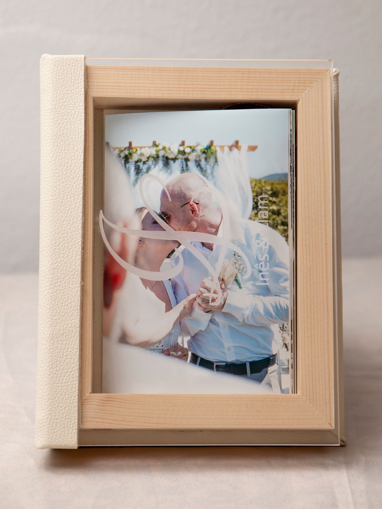 A framed wedding photo displayed in a cream-colored frame with floral decorations.