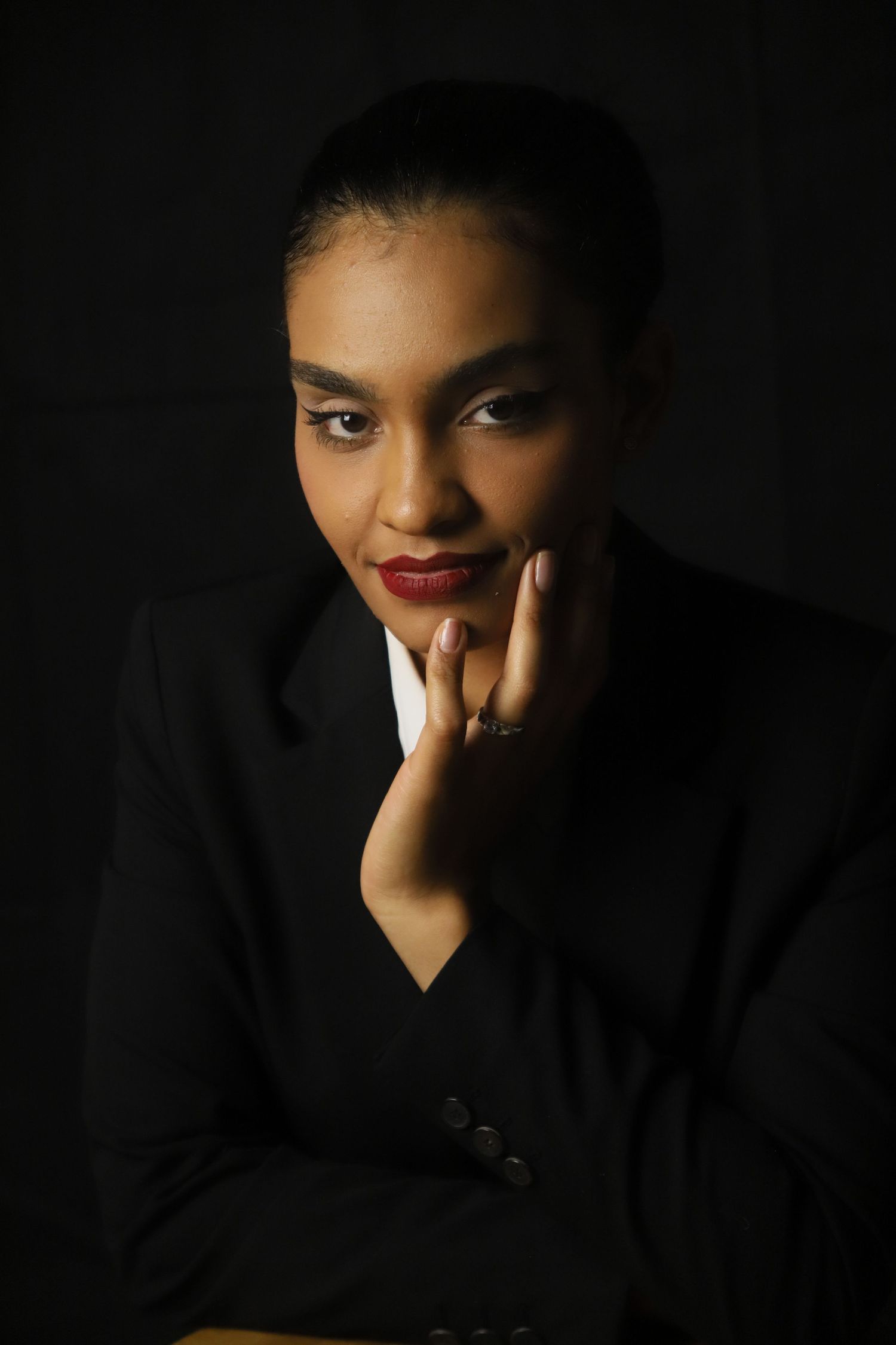 Moody studio portraits on black background showcasing artistic lighting and expression.