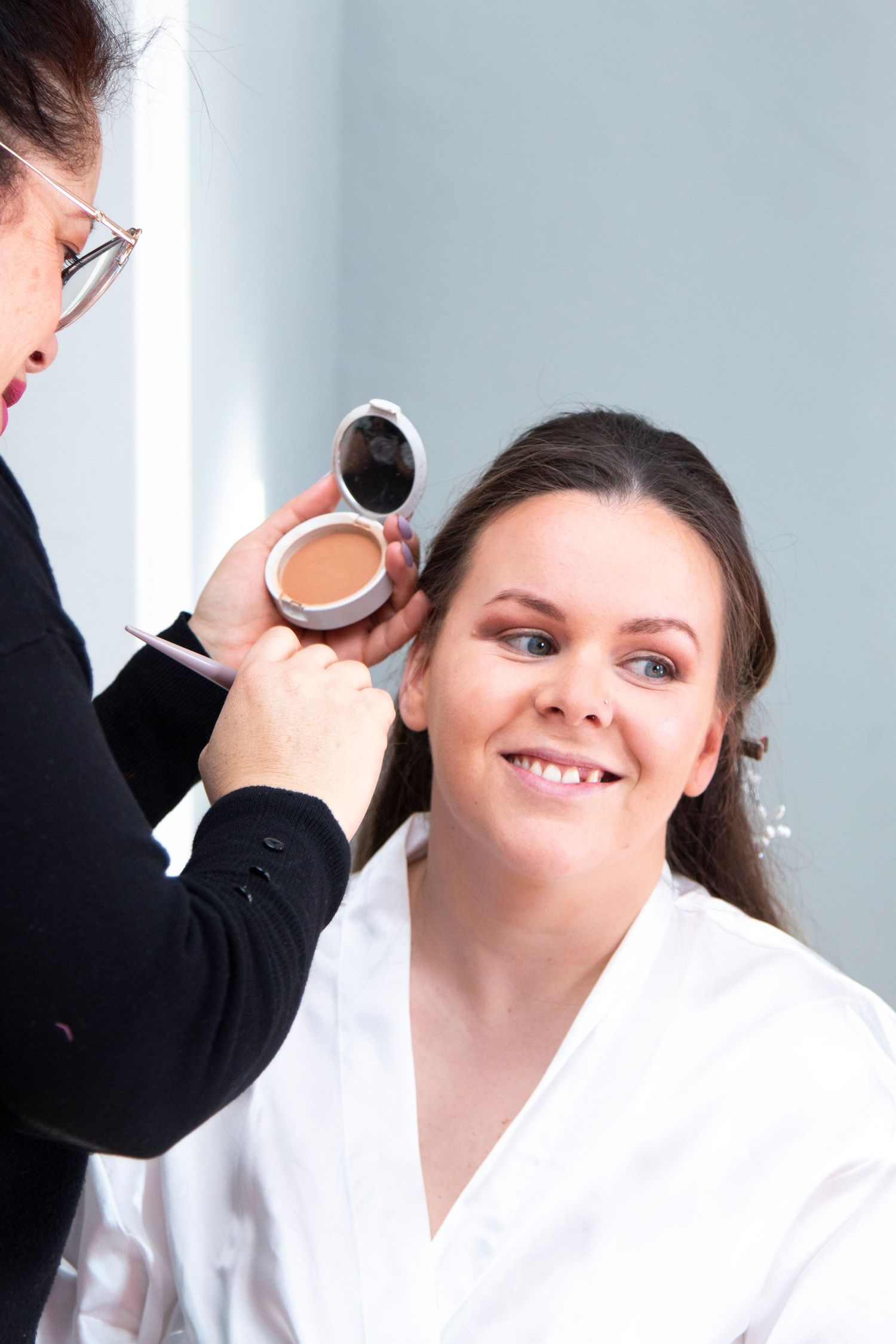 Professional makeup application during wedding preparation.