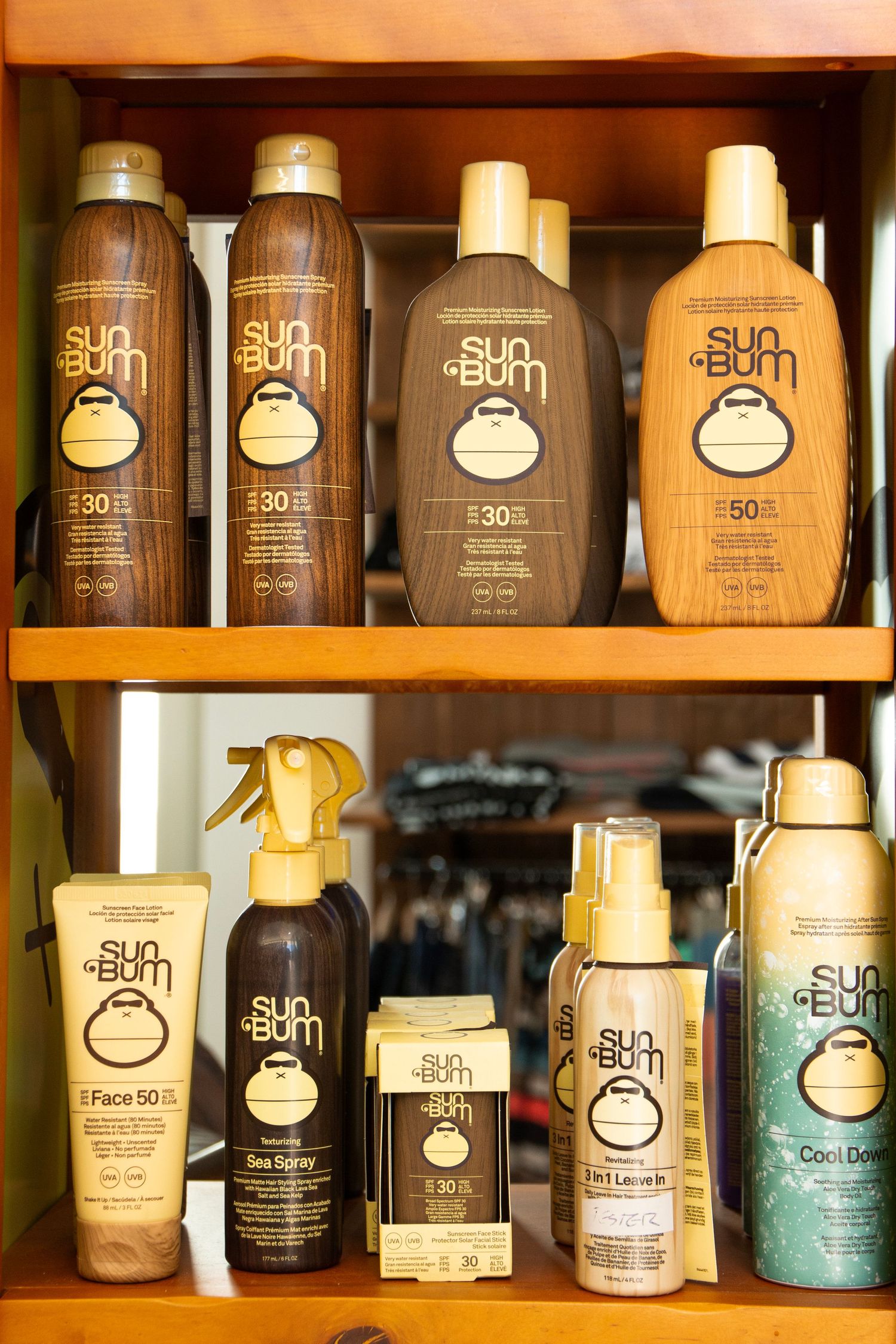Collection of sun protection products arranged on wooden shelves with warm lighting.