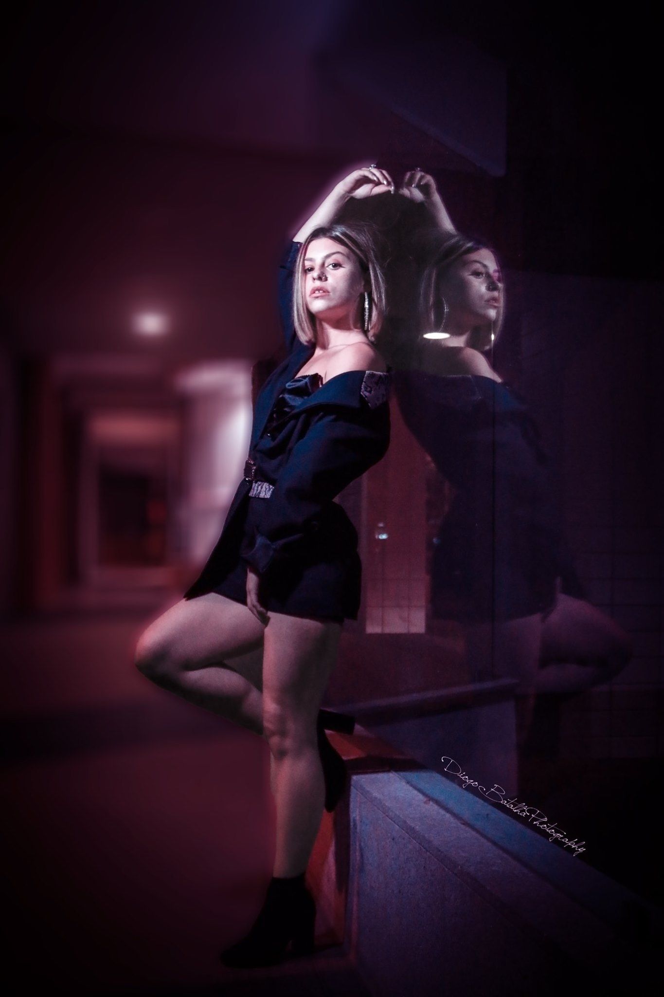 Artistic portrait with reflection showing silhouette making heart shape in dark room.
