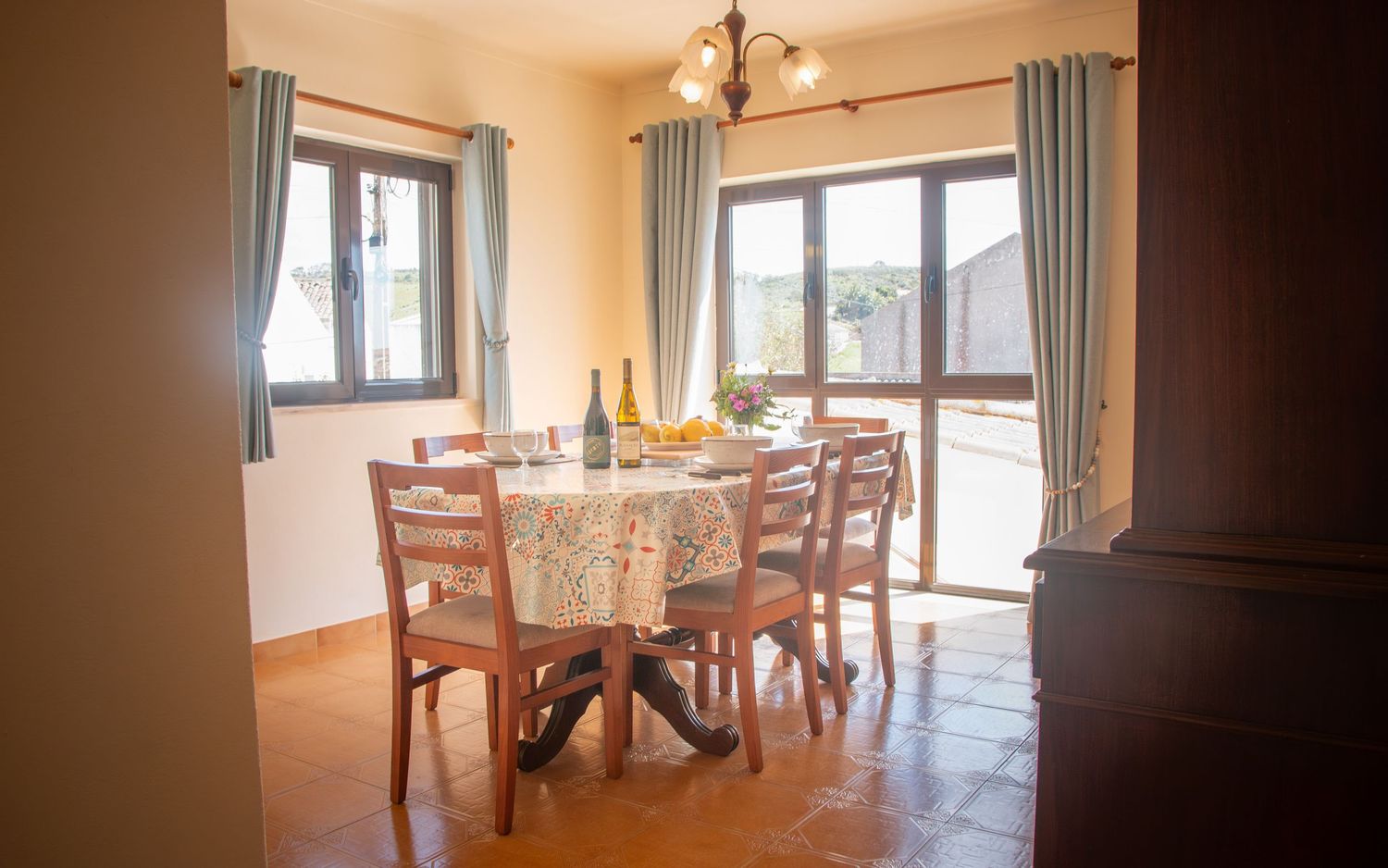 Bright open-concept room with hardwood floors, large windows, and elegant traditional dining furniture in warm tones.