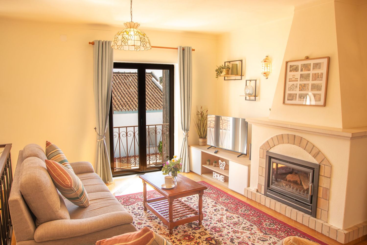 Warm and inviting living room interior with beige walls, stone fireplace, and comfortable brown leather furnishings.