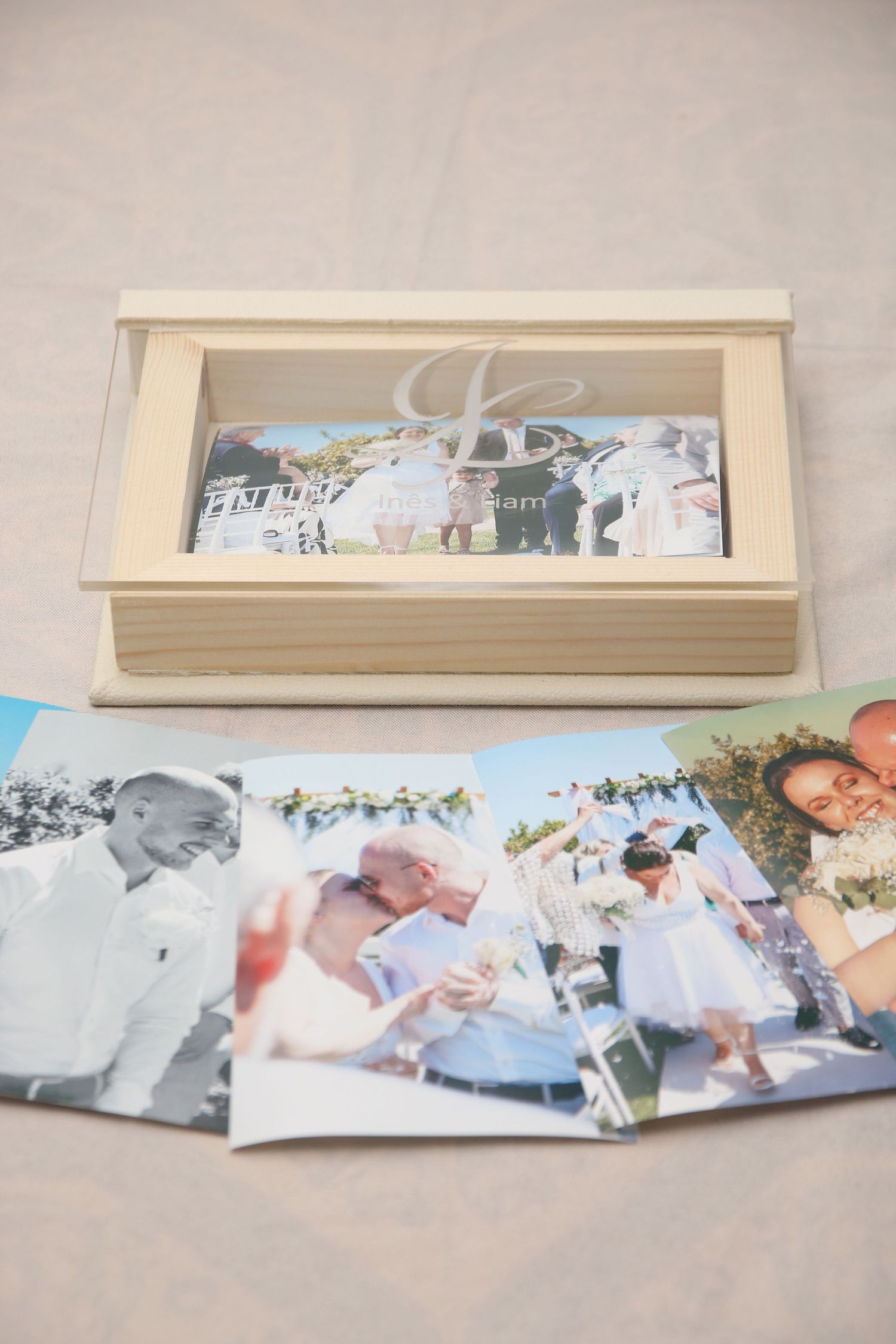 Wedding photos arranged near a decorative wooden box containing more photographs.