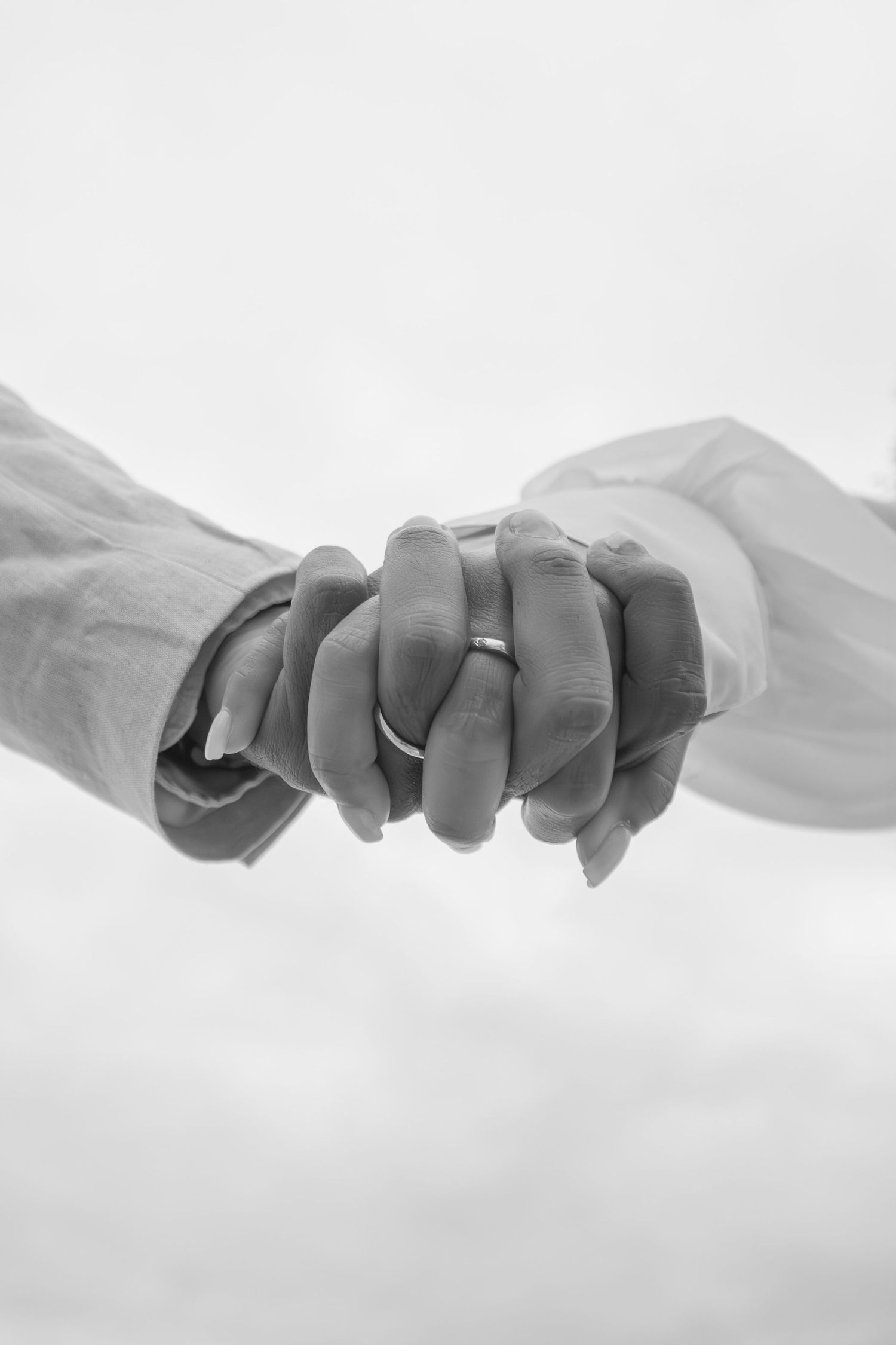 A black and white composite of multiple hands grasping and holding poses in sequence against a white background.