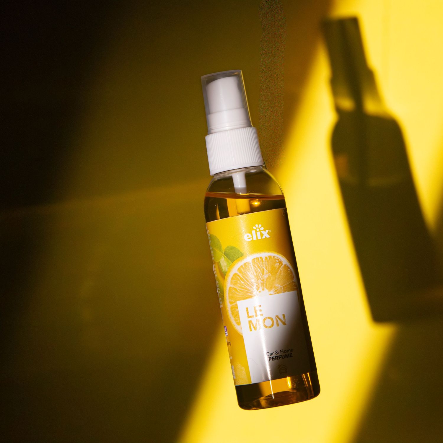 Blix lemon-scented spray bottle on a vibrant yellow background with citrus label and dramatic shadows.
