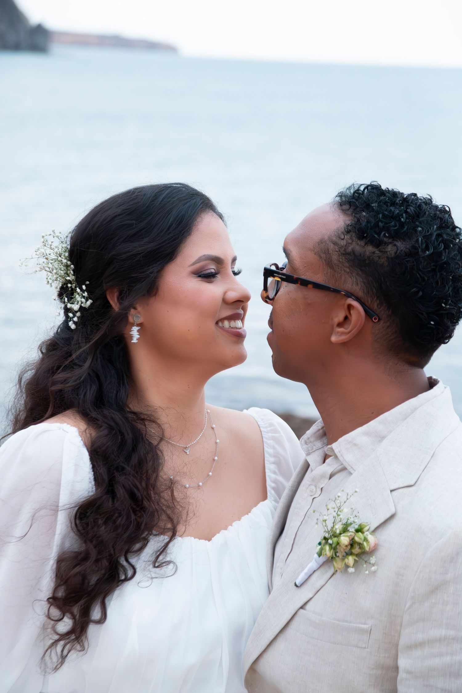 Four sequential wedding photos showing a romantic moment between newlyweds dressed in elegant white attire against a bright background.