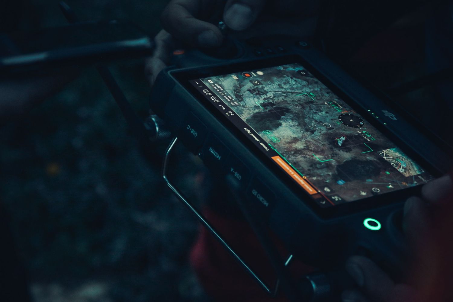 Rugged mobile device displaying navigation interface in dark environment.