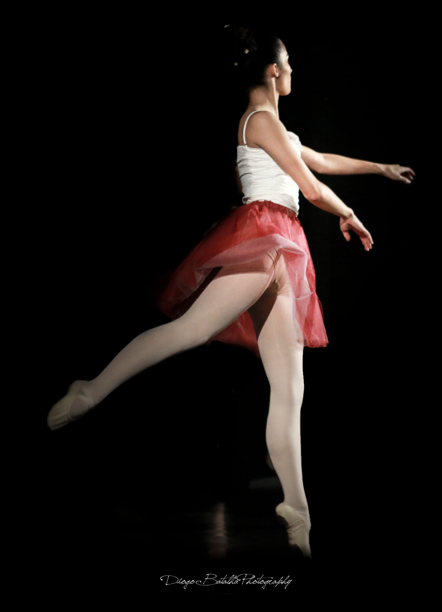 Ballet dancer in white leotard and pink tutu performing graceful poses against black background.