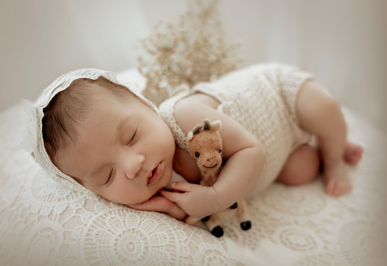 A serene collage of newborn baby photos with soft white blankets and delicate knit textures captured in warm lighting.
