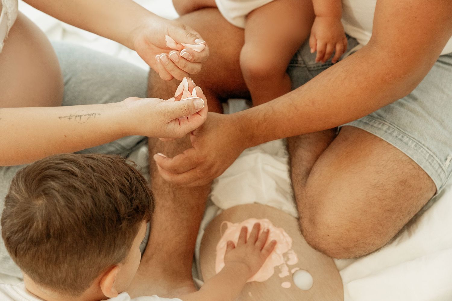 Hands gently massage a baby's head and neck during a relaxing infant massage therapy session.