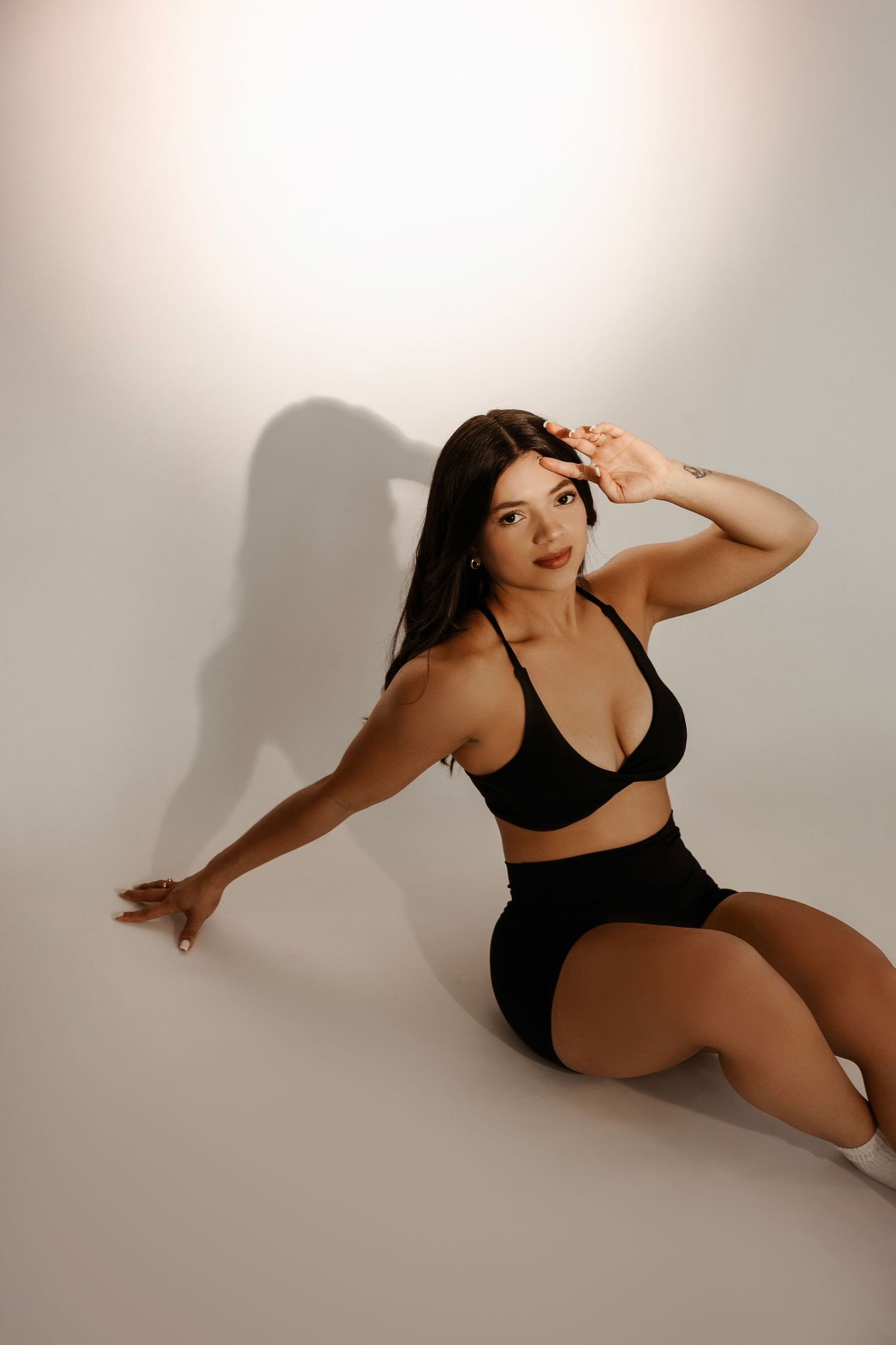 A figure in black athletic wear poses gracefully in a series of dynamic dance movements against a light background.