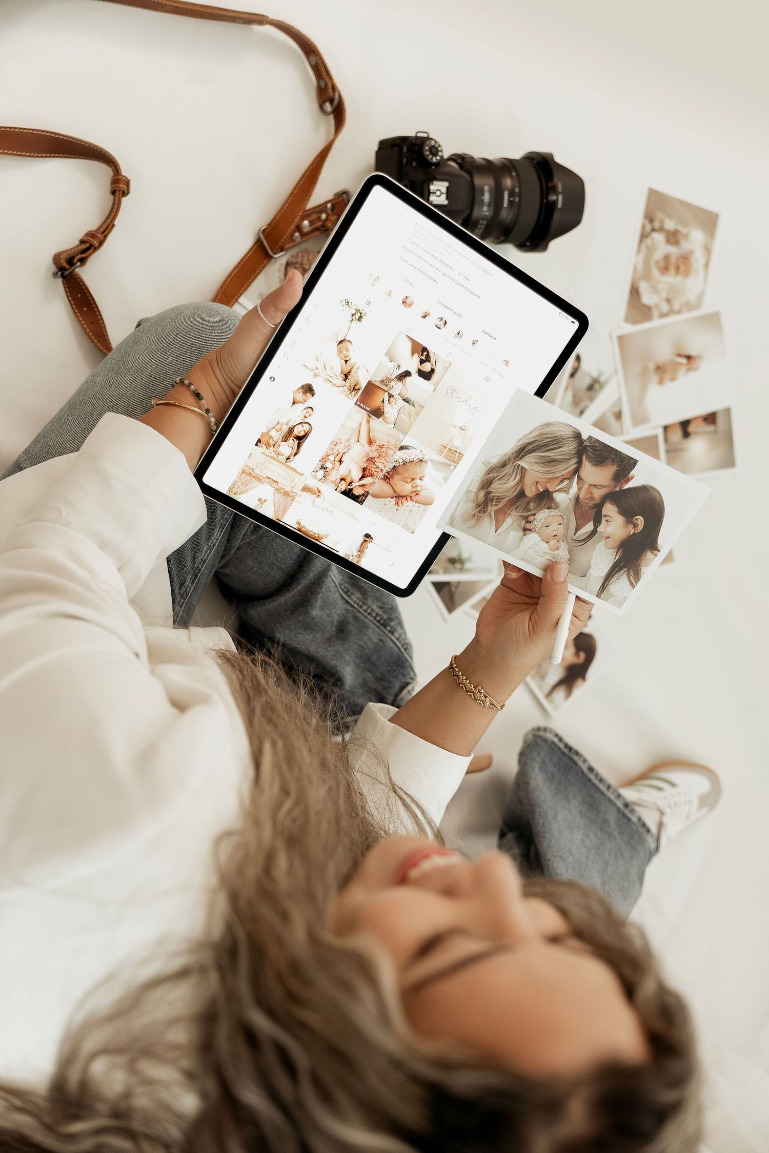 Person lying down looking at photos on digital tablet while wearing cozy gray sweater and white top.
