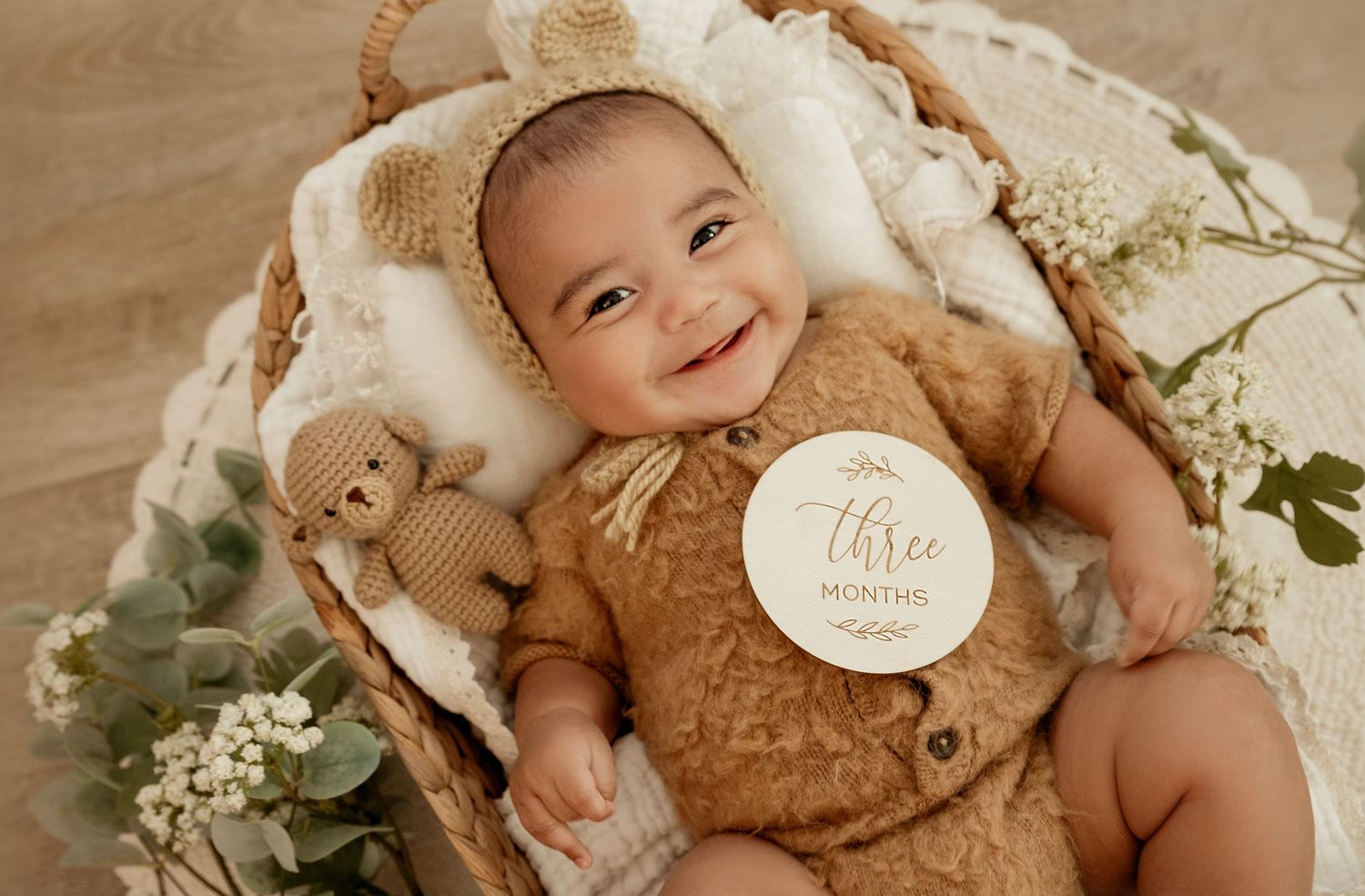 Cozy newborn photography studio setup with soft teddy bears, white floral accents and delicate lace details.
