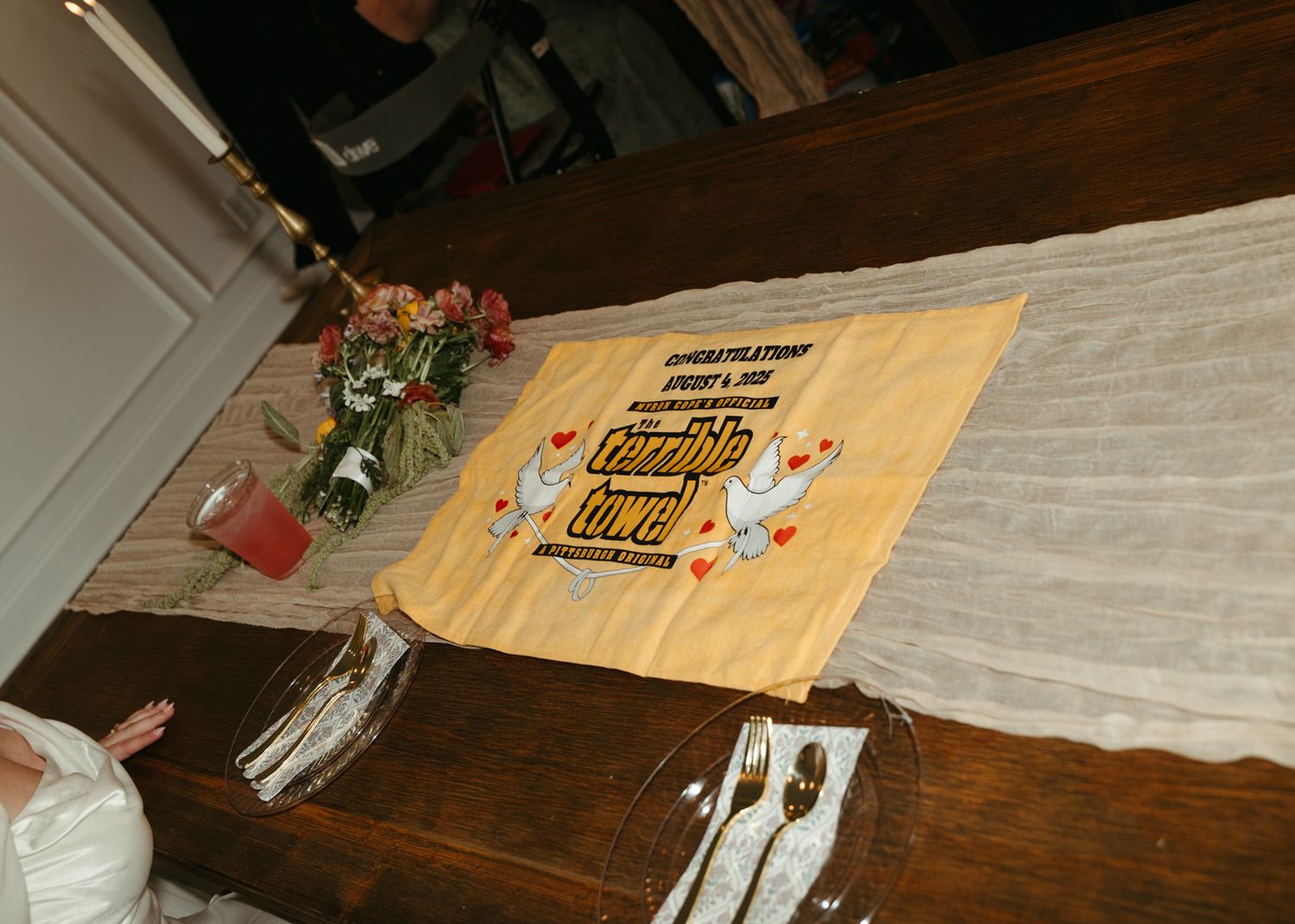 Personalized congratulations cutting board displayed on rustic wooden table at wedding reception.