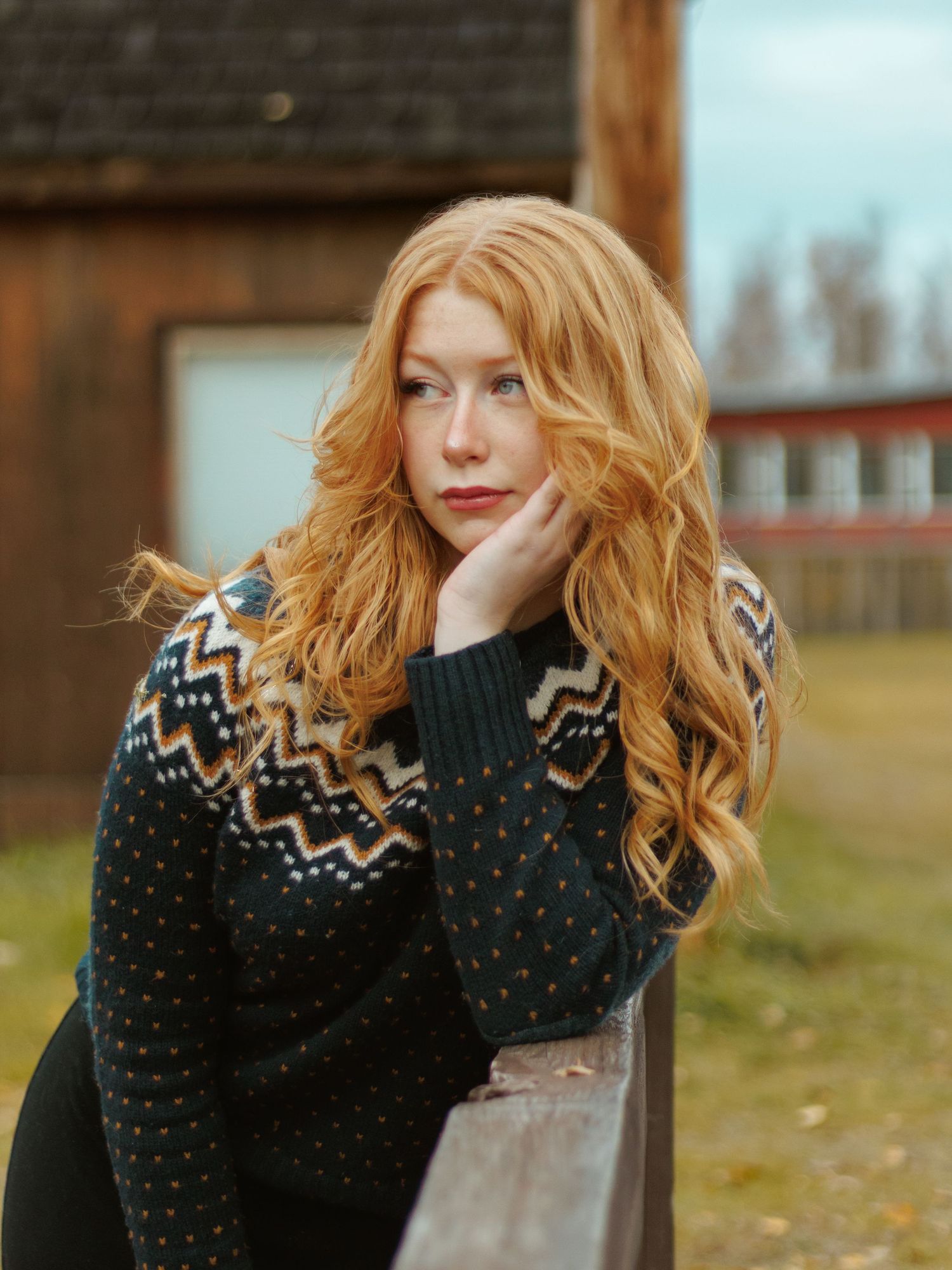 A series of outdoor portraits showing long wavy ginger hair against a dark knit sweater with geometric patterns.