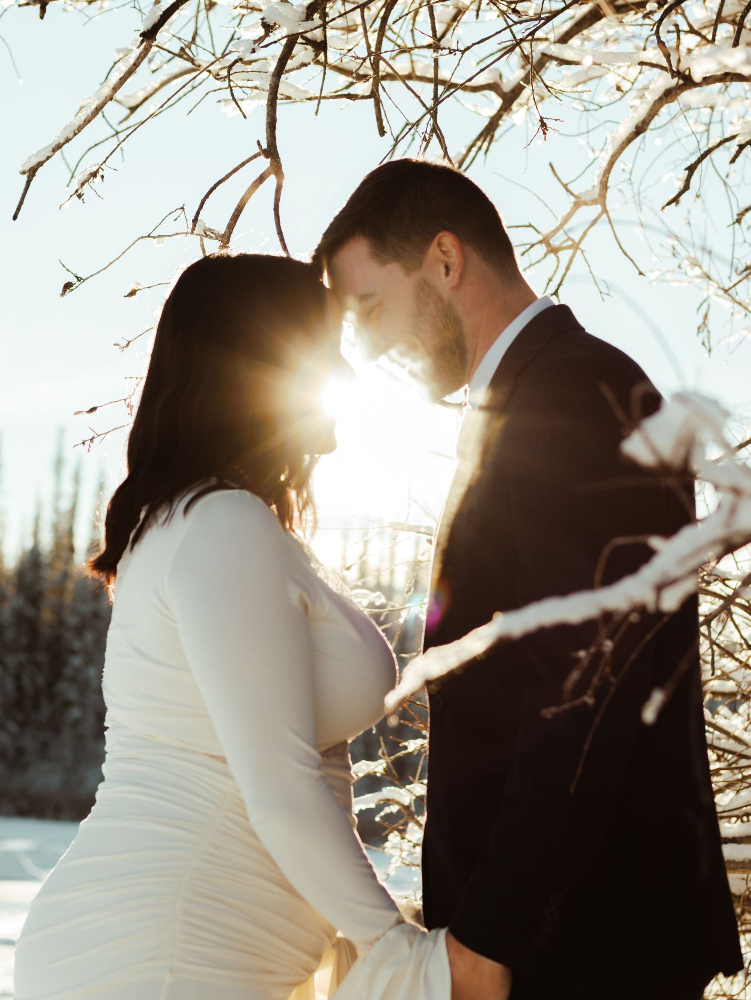 Winter engagement photoshoot sequence with sunlight streaming through bare branches.