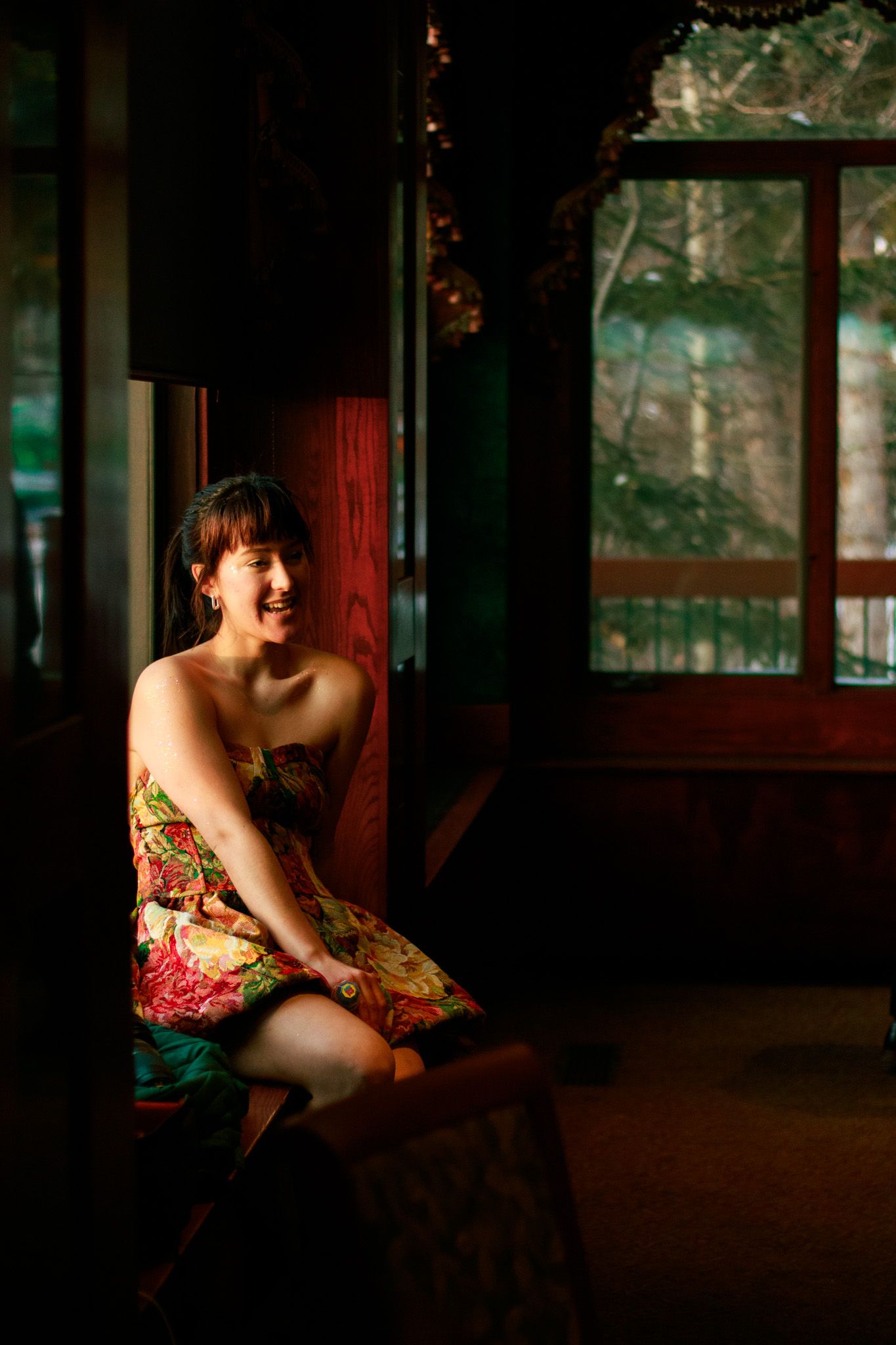 Artistic boudoir photography in a dimly lit room with warm ambient lighting.