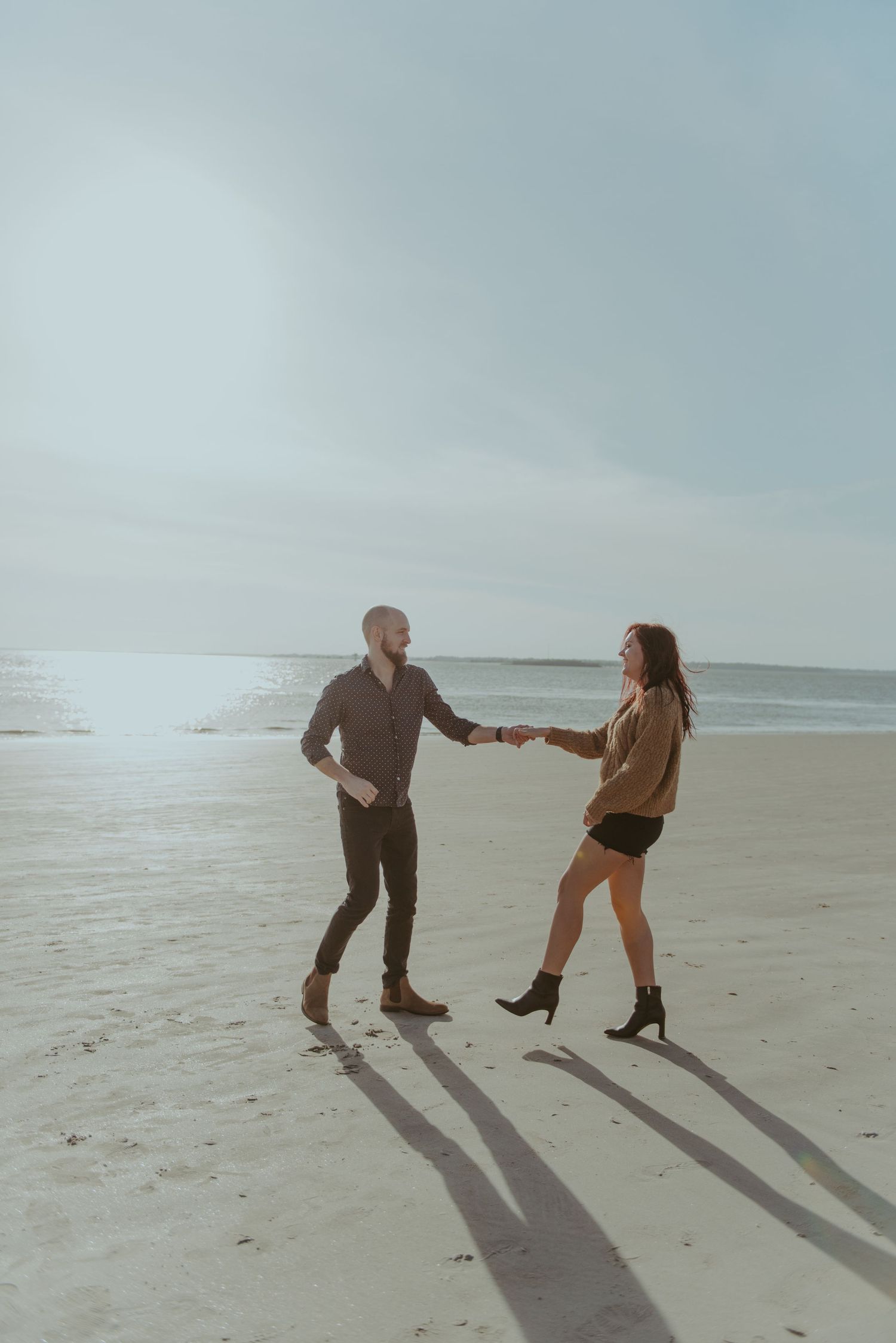 A couple are dancing on the beach.