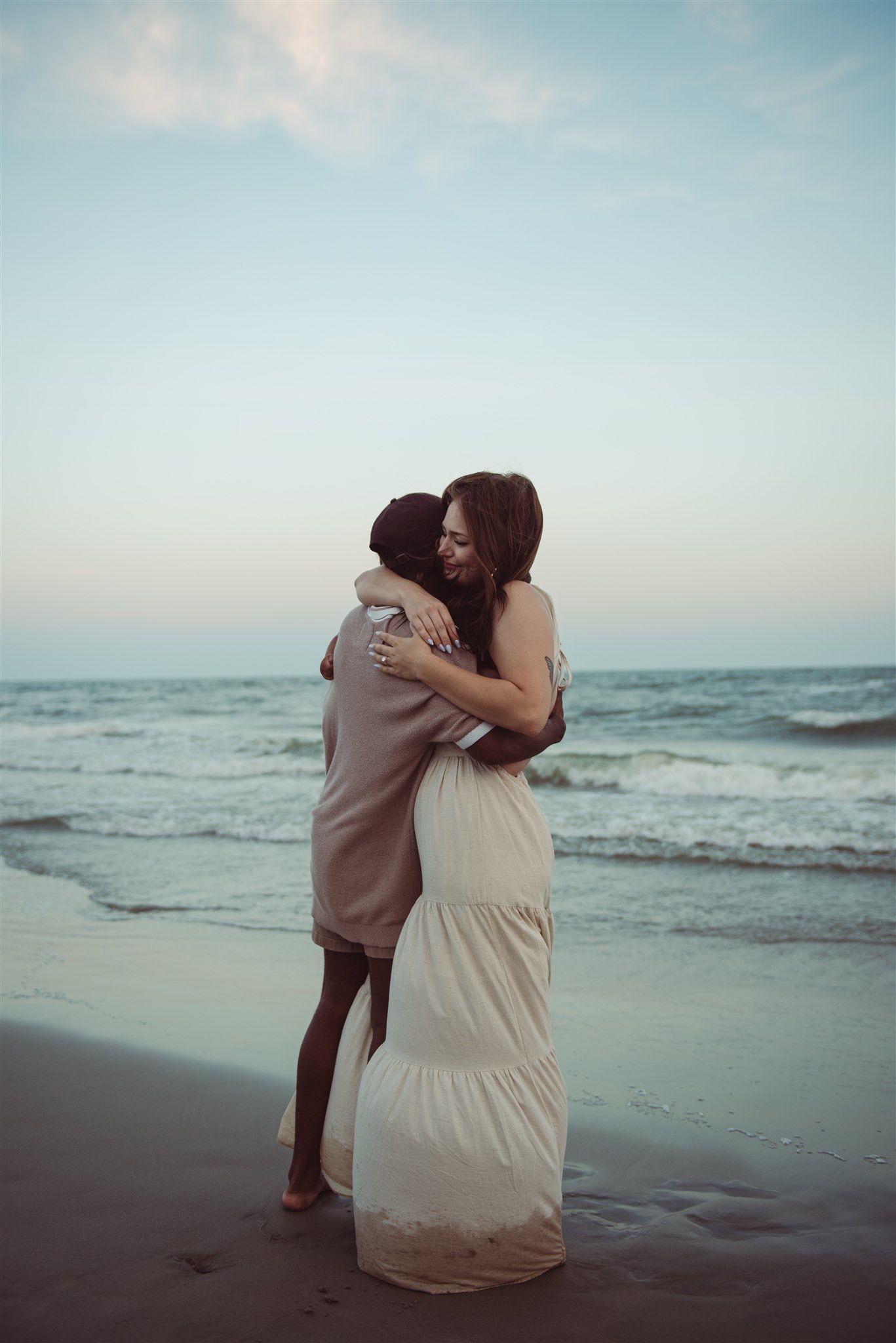 A couple is embracing on the beach in Charleston, South Carolina.