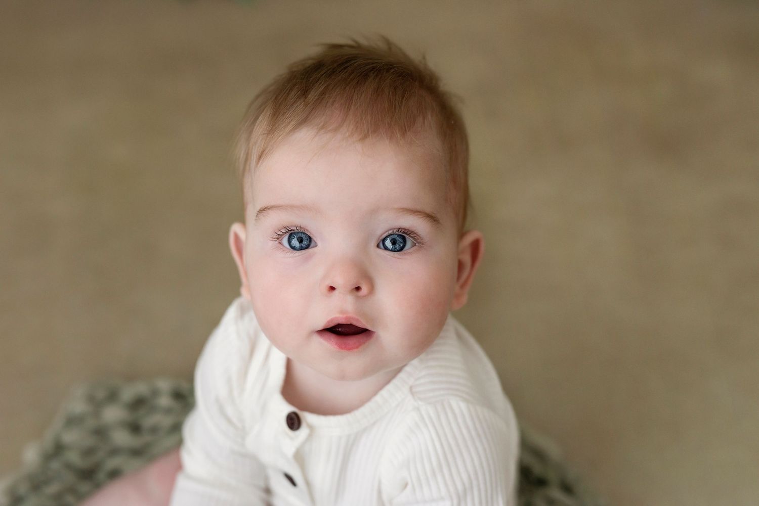 Collection of baby milestone photos showing growth and development against neutral backdrop.