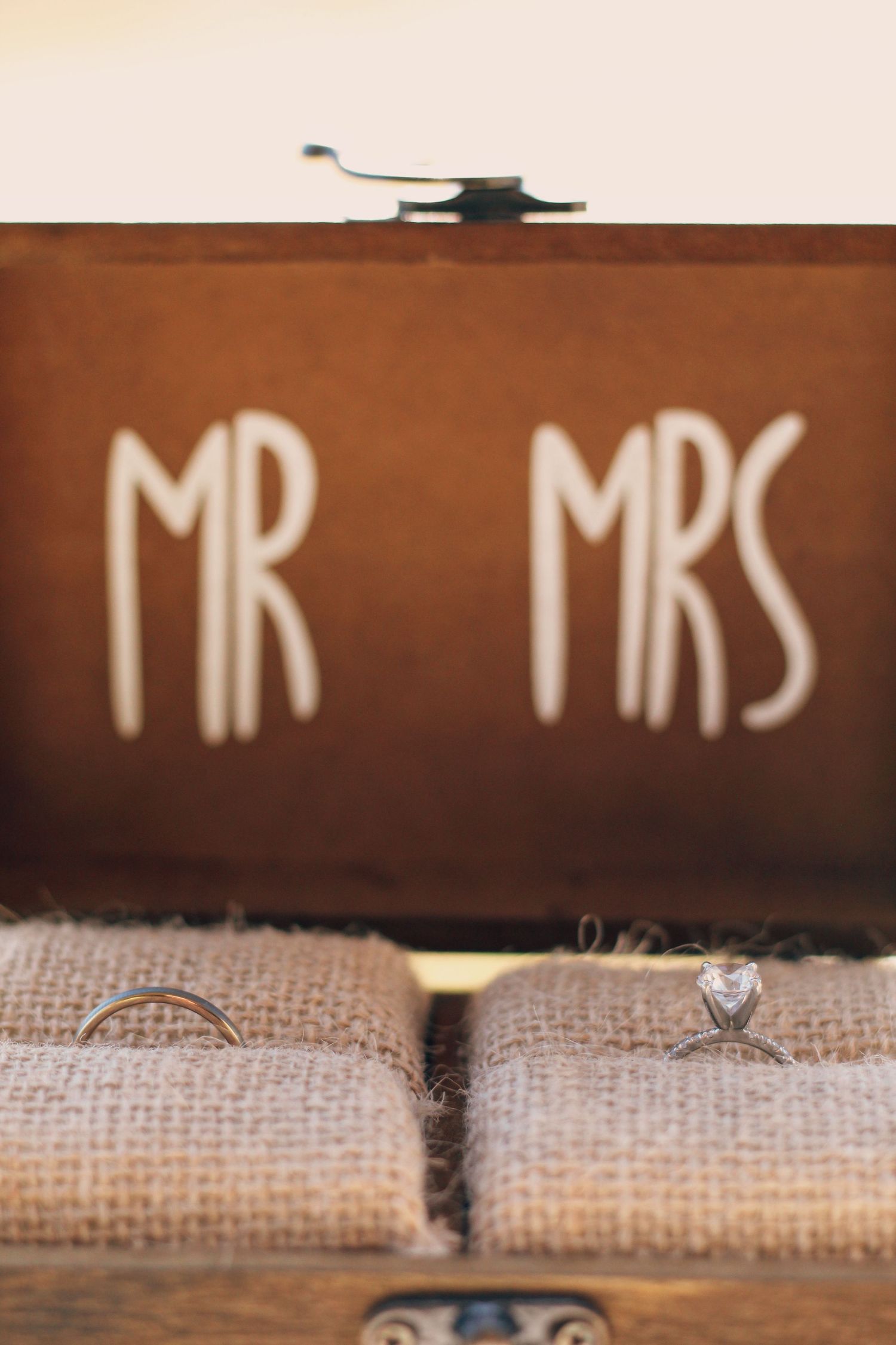 Wedding rings displayed on burlap with Mr and Mrs text sign.
