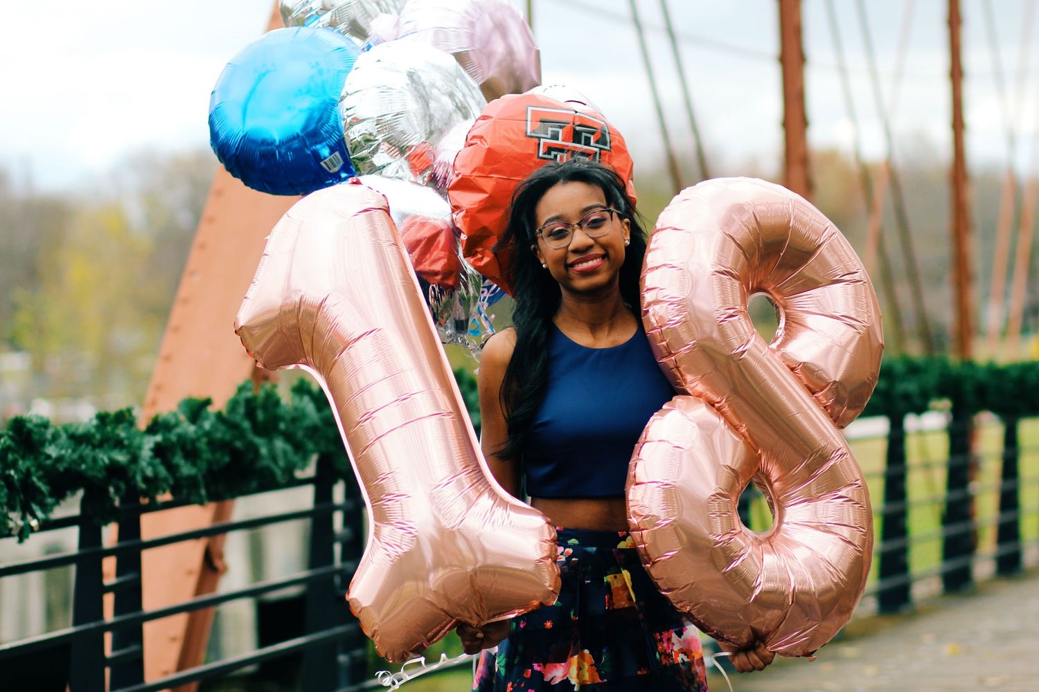 A joyful celebration with rose gold number balloons in an outdoor setting.