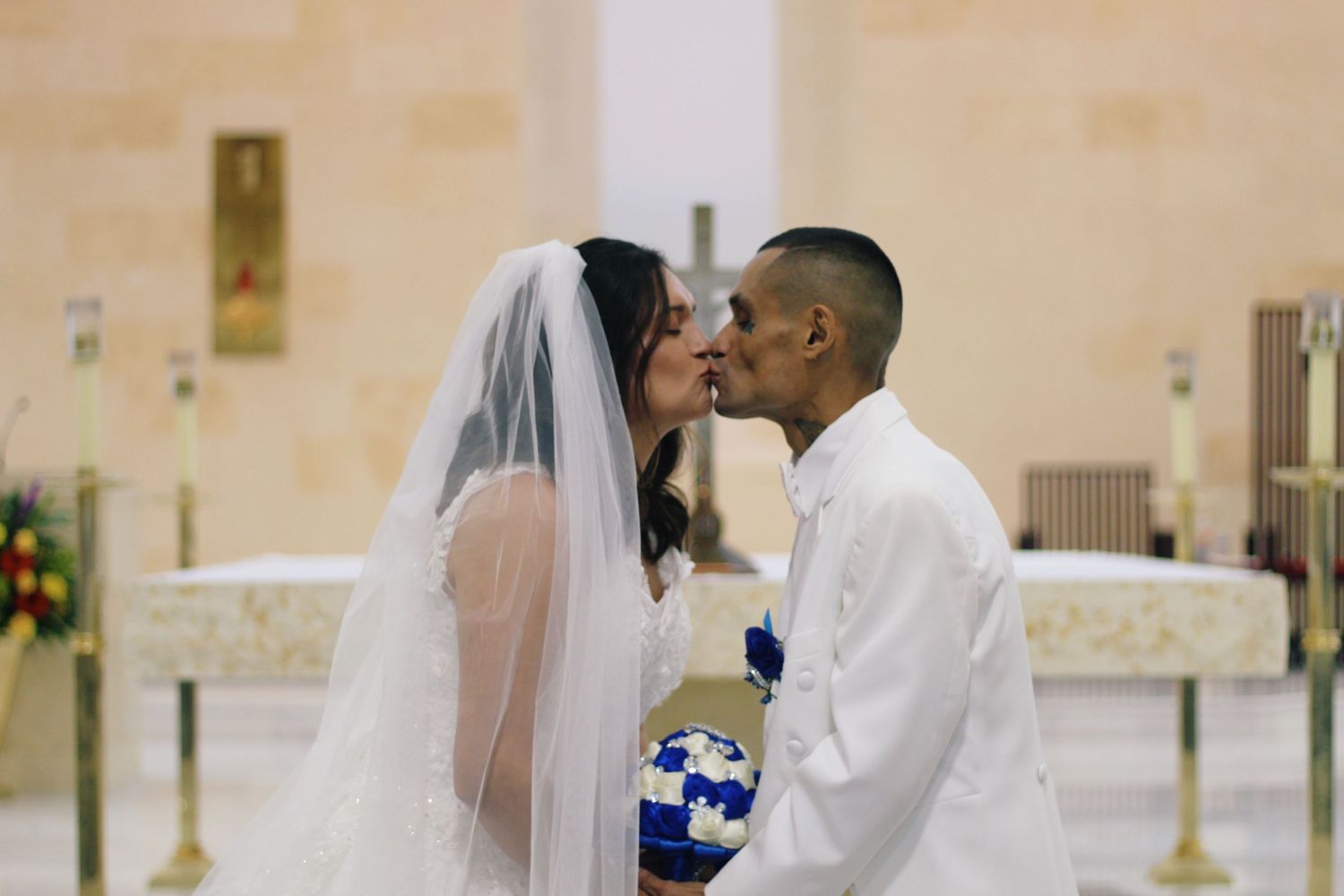 A tender moment captured during a wedding ceremony with a bride in white veil.