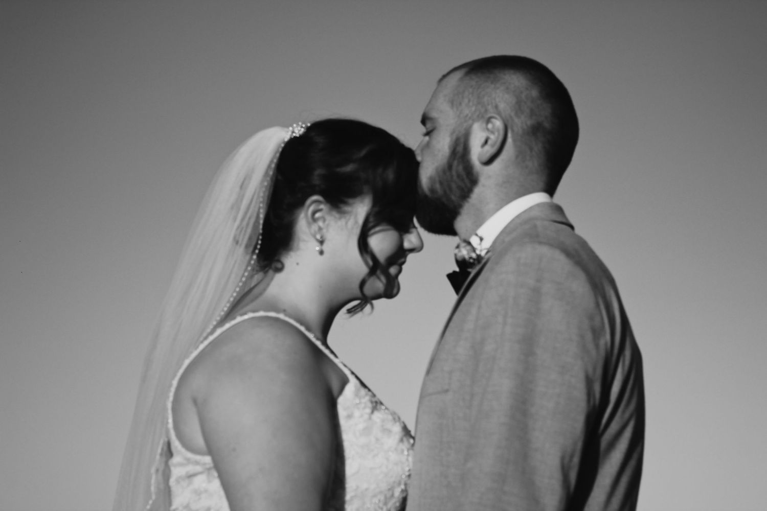 Black and white portrait of newlyweds in an intimate pose.