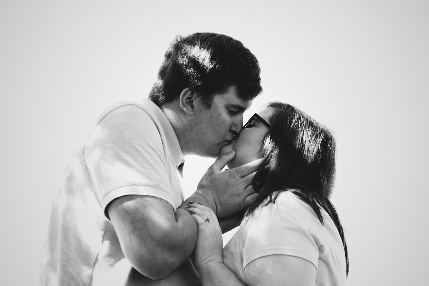 A tender black and white portrait of a couple sharing an intimate romantic moment.