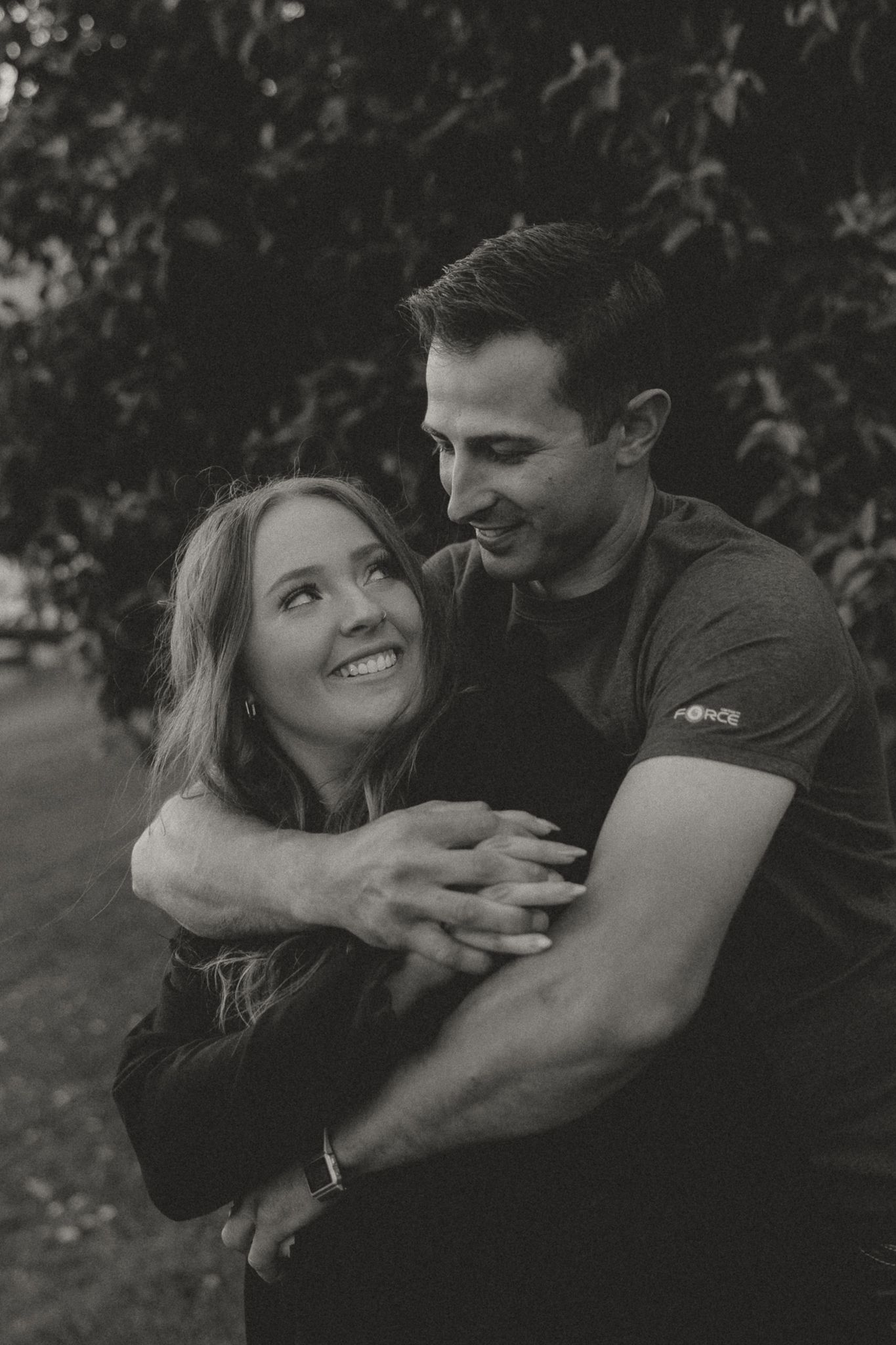 A couple embraces and laughs together during an outdoor photoshoot.