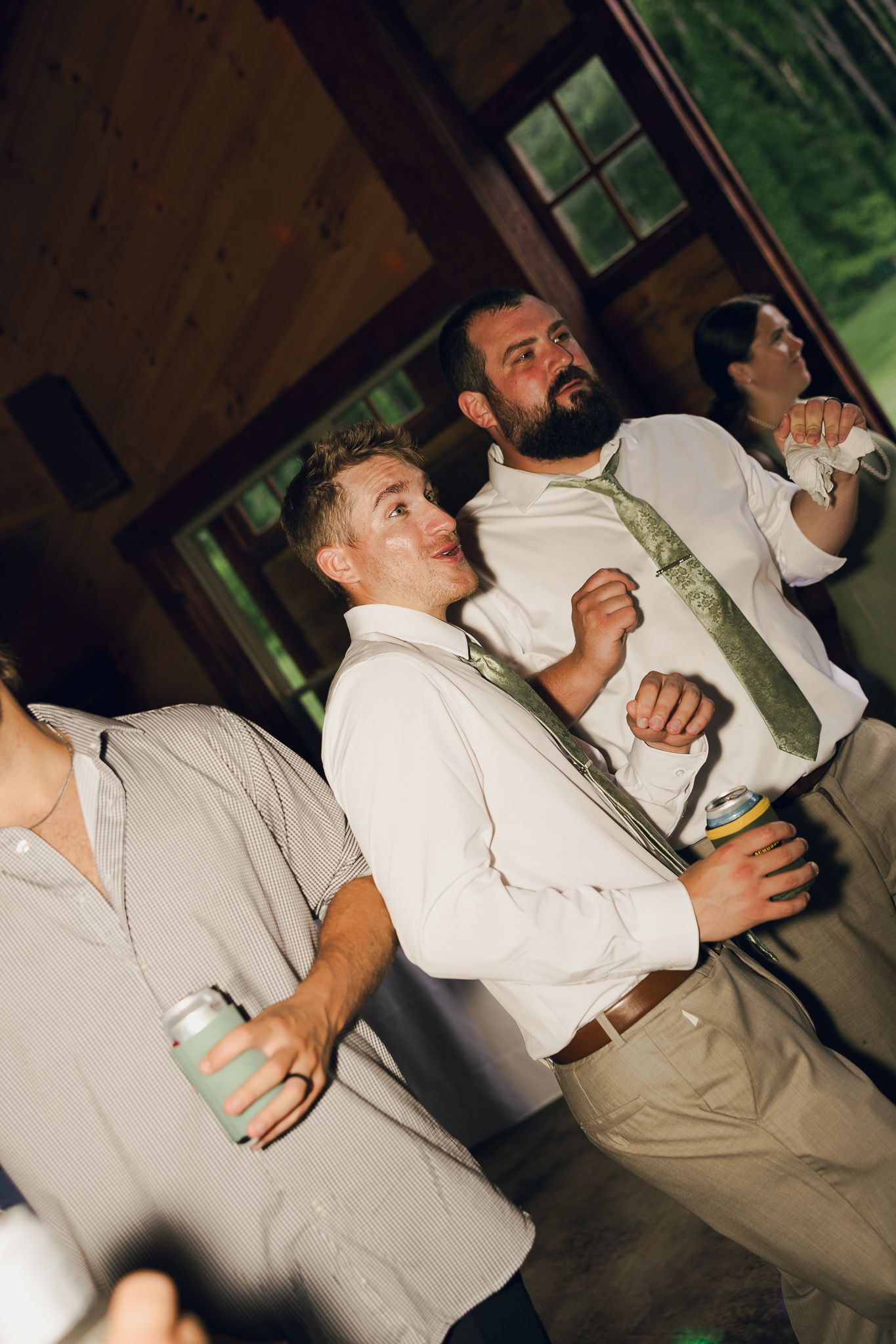 Wedding party members dancing and celebrating in matching light colored attire.