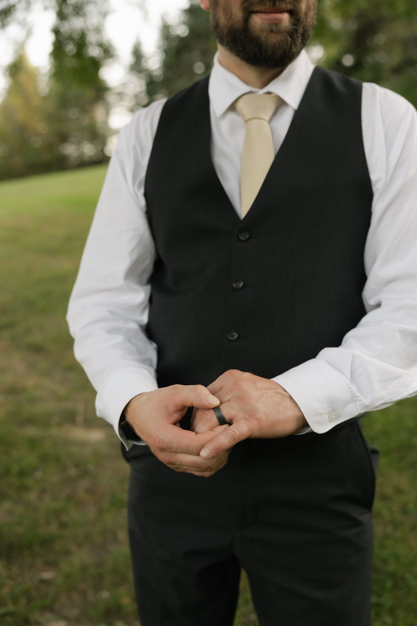 Close-up of formal attire showing black vest and gold tie details.
