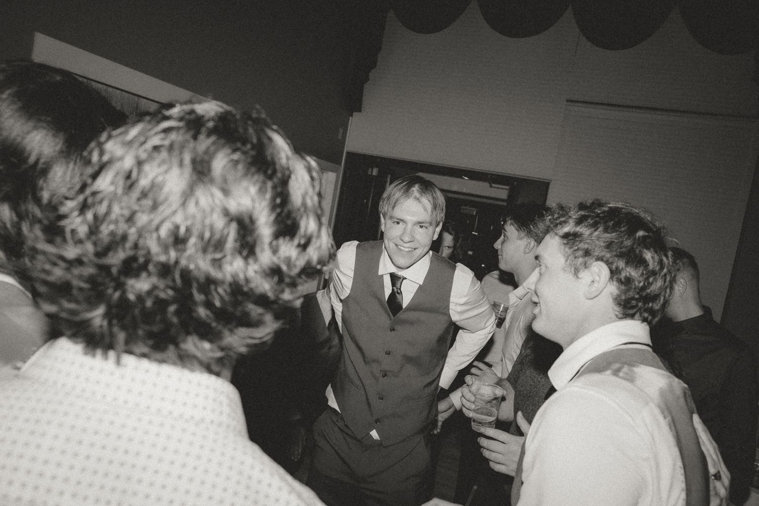 Black and white photo of guests mingling at a formal event.