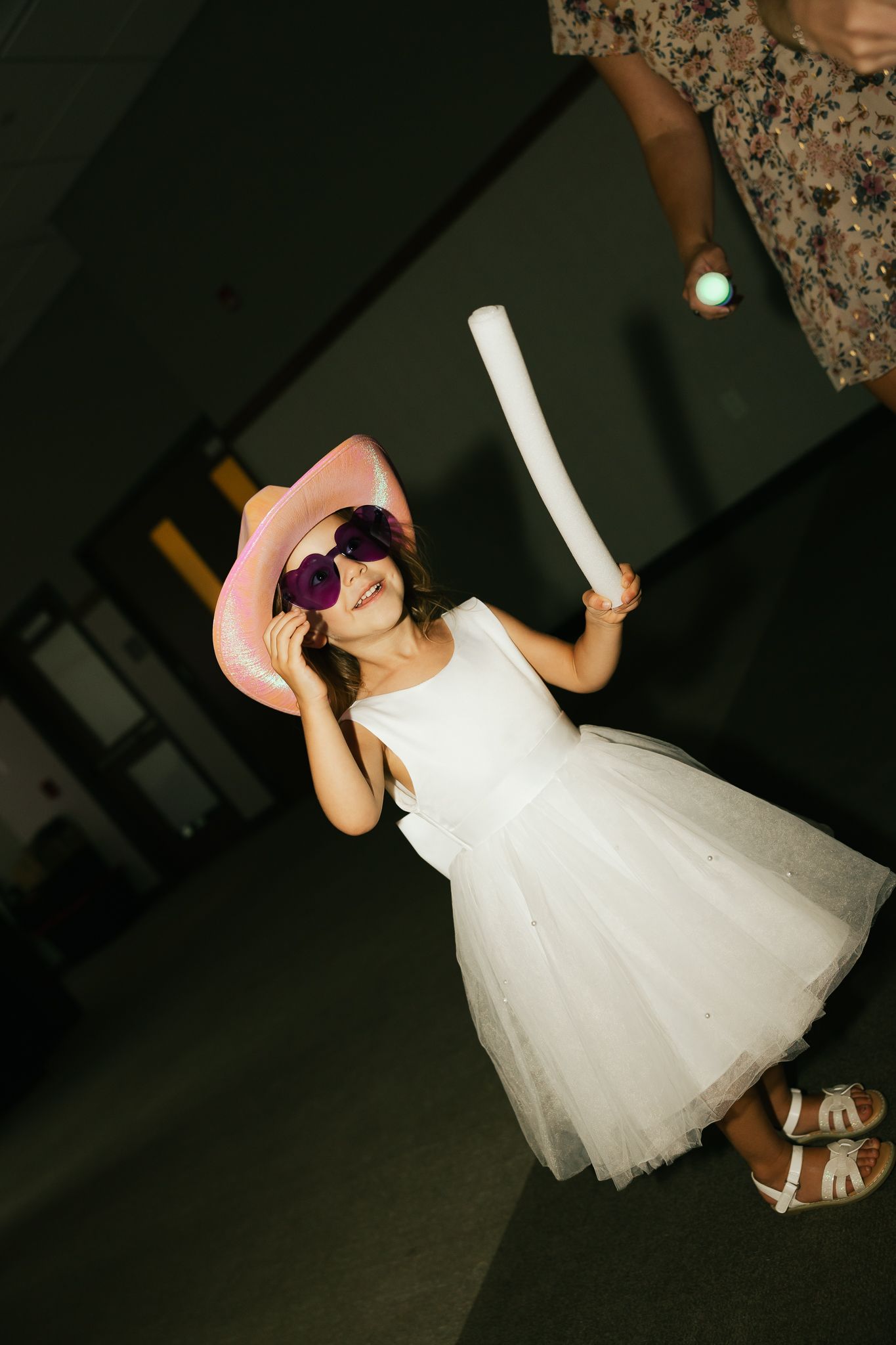 Person in a white tulle dress dancing at a reception.