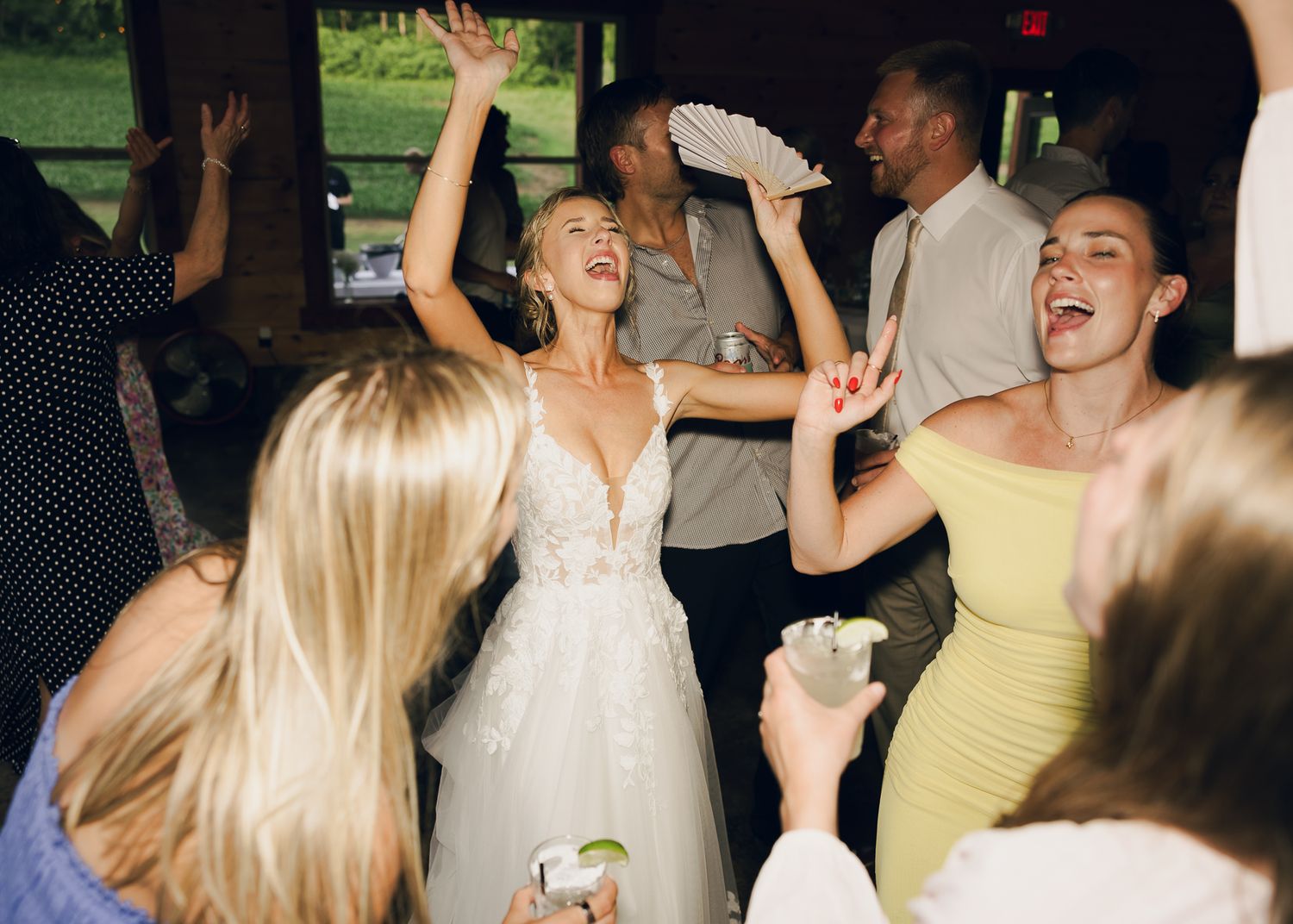 Wedding reception guests dancing and celebrating on a lively dance floor.